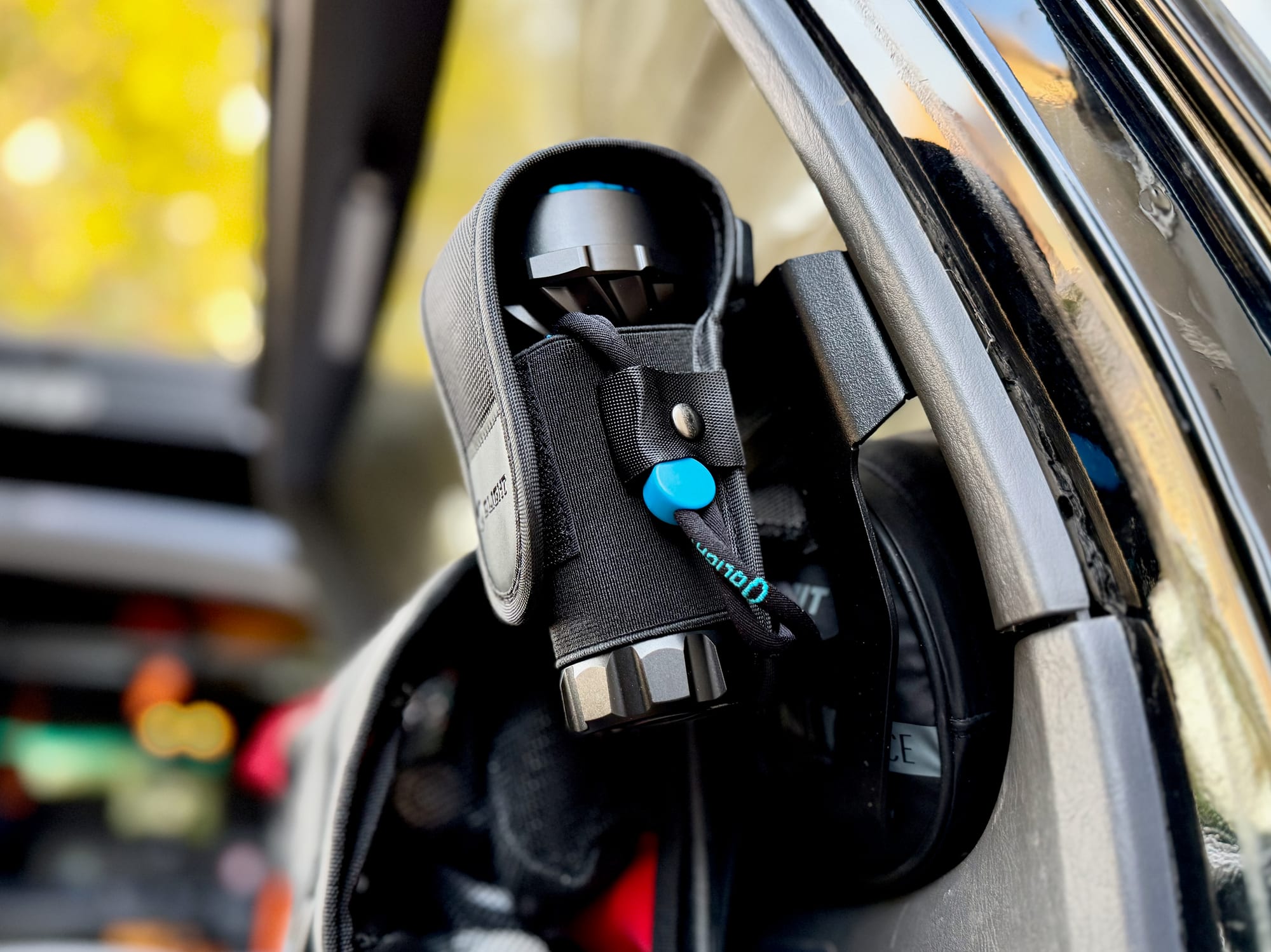 The Marauder Mini in its holster, tucked into the door pocket of a 4WD