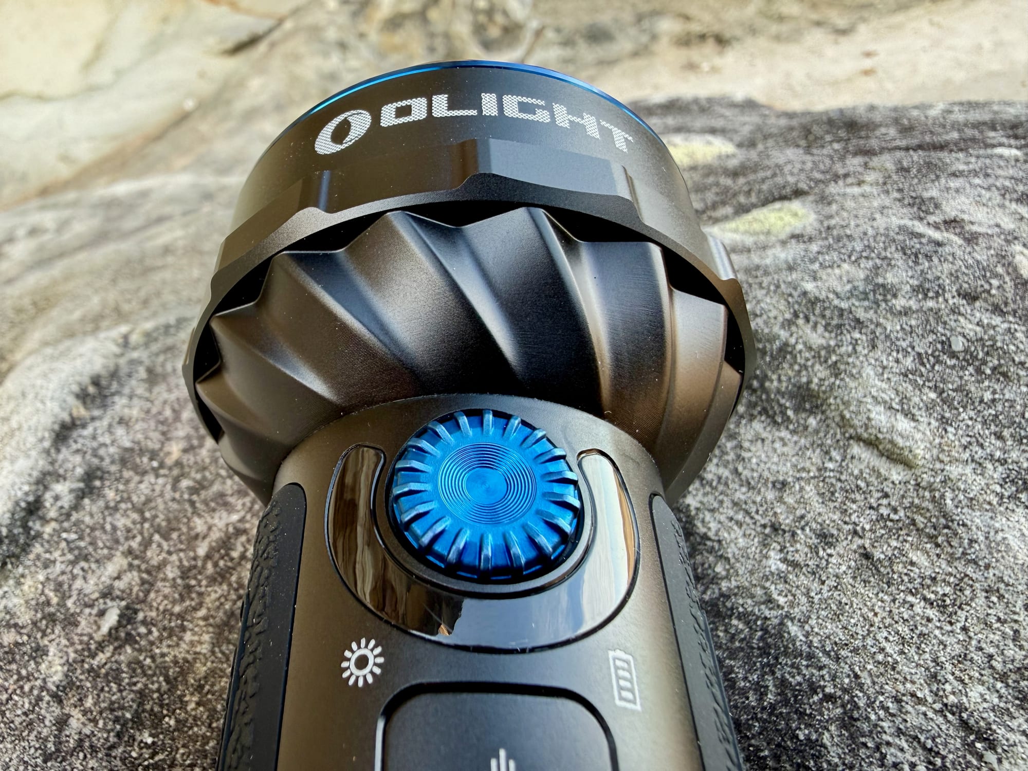 The blue rotary dial and side switches of the Olight Marauder Mini