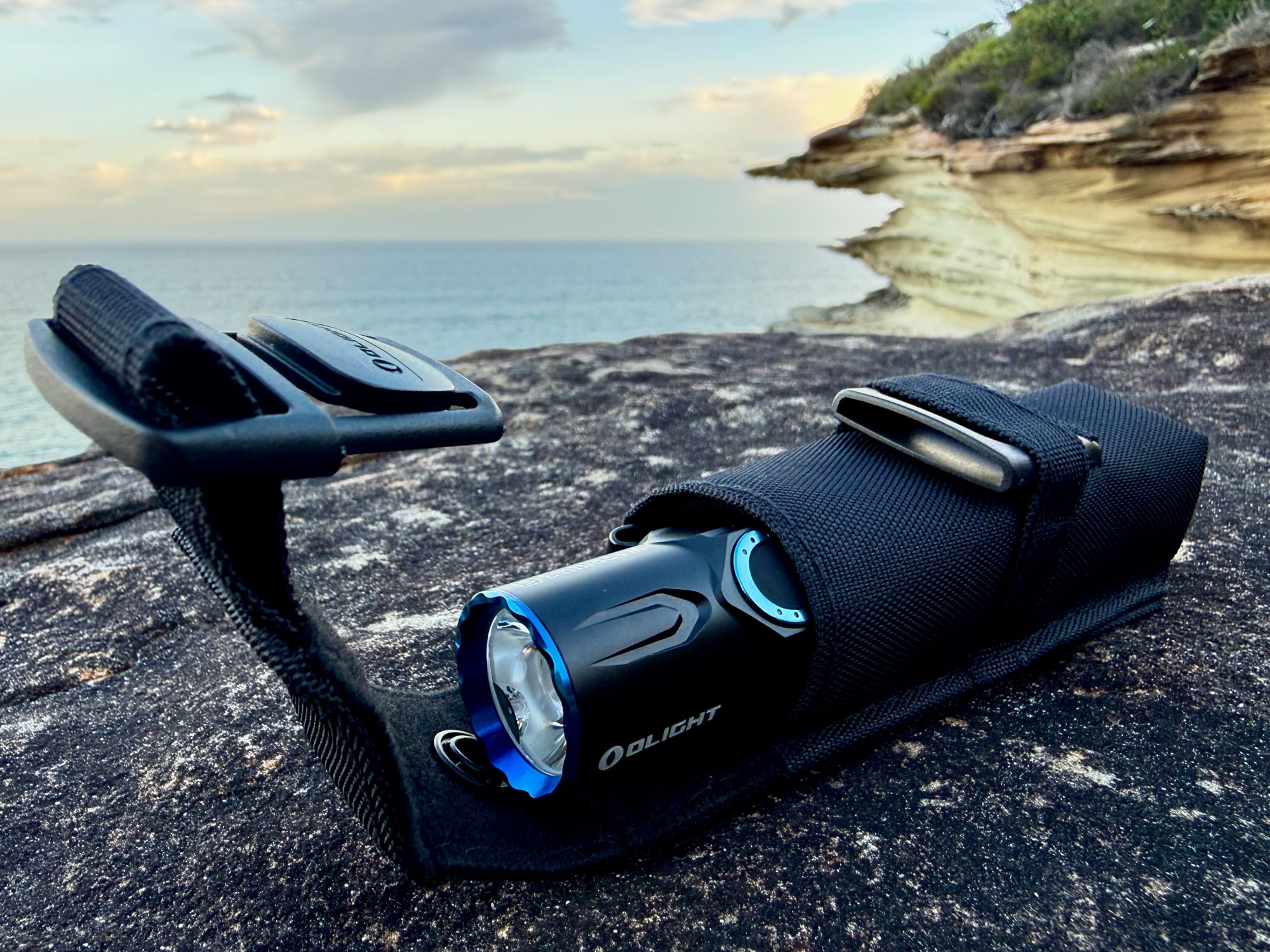 The Warrior 3S in its nylon holster on a rock, with the flap open