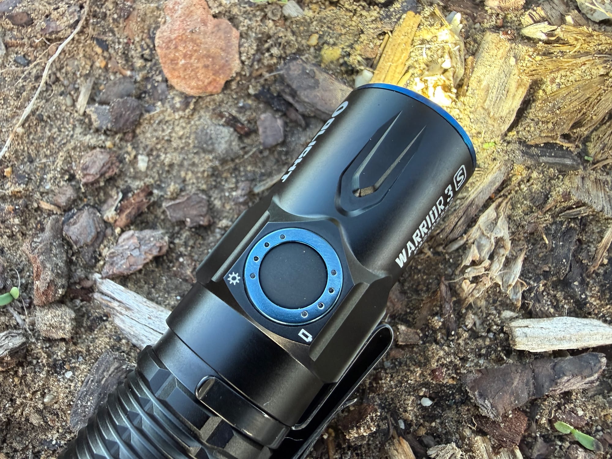 Close-up of the Warrior 3S side switch with its blue ring of battery and brightness lights