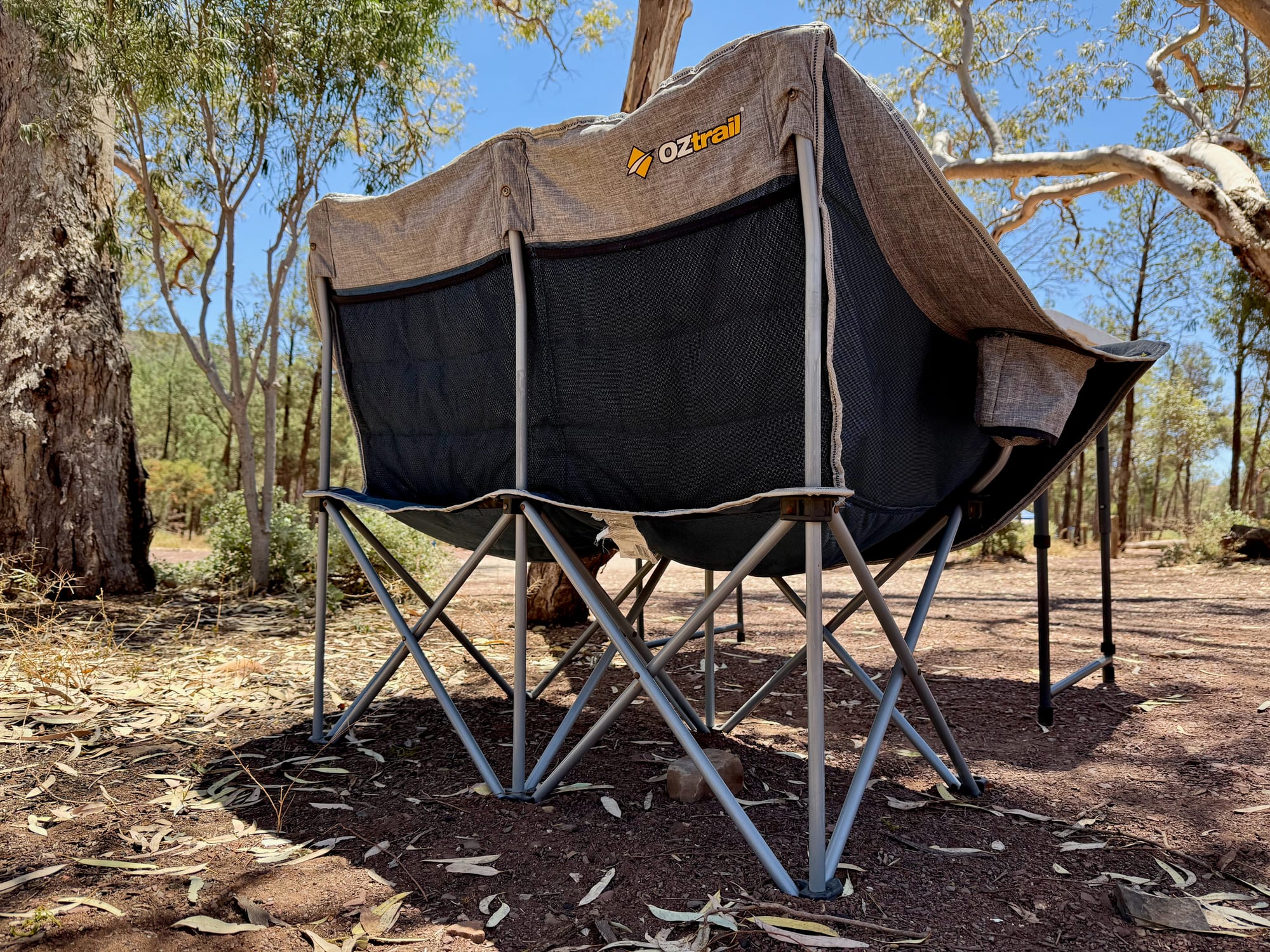 The OZtrail Galaxy 2 seater from behind, showing the steel frame, the legs and the mesh pockets in the backrest