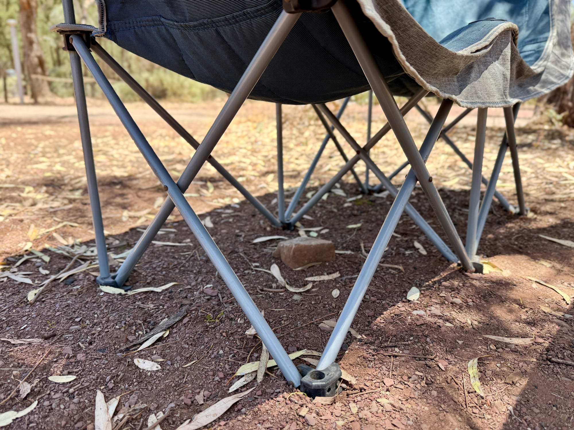 The folding steel frame and legs of the OZtrail Galaxy 2 seater on red dirt