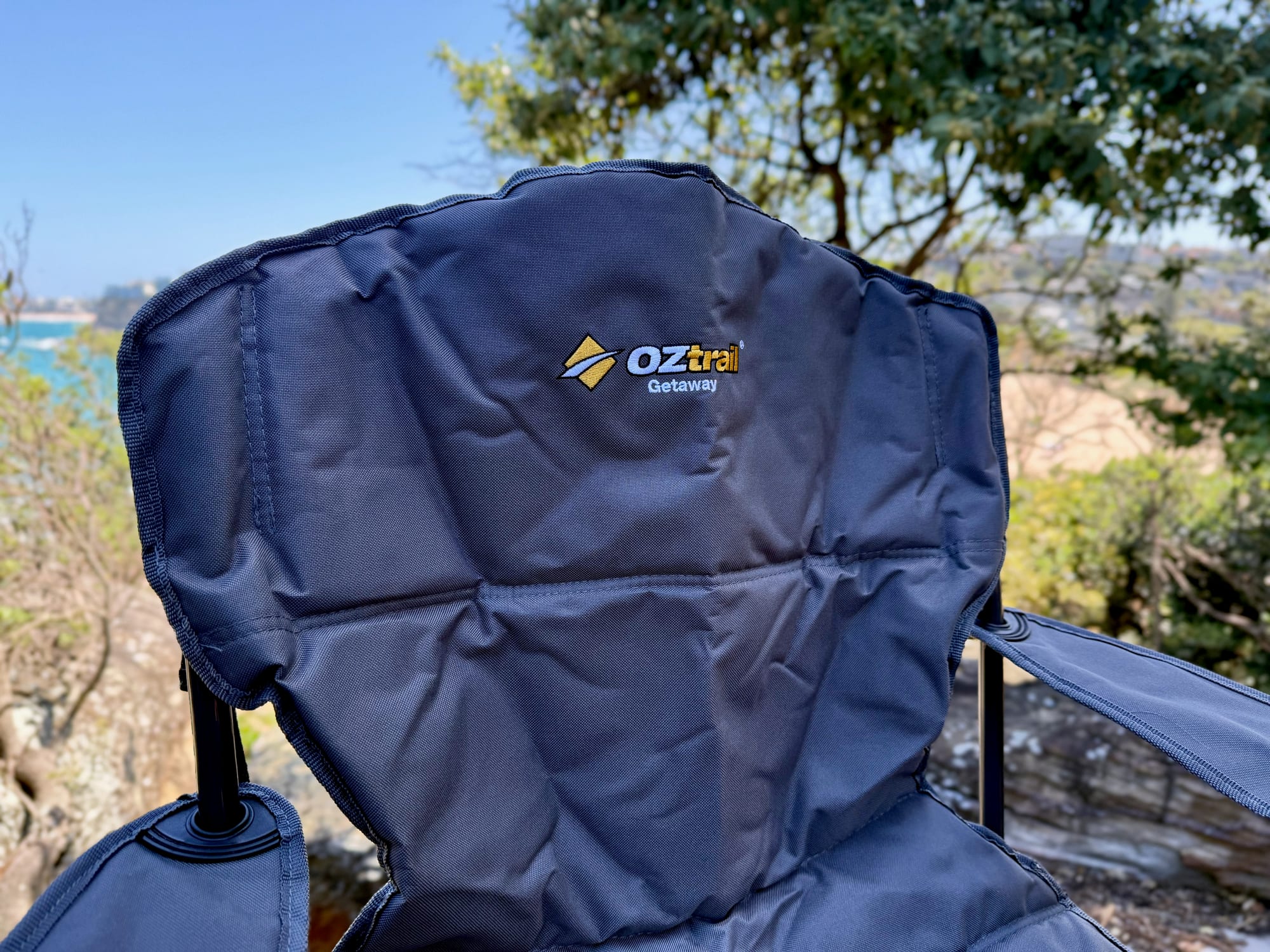 The padded high backrest of the OZtrail Getaway Chair, with the embroidered logo