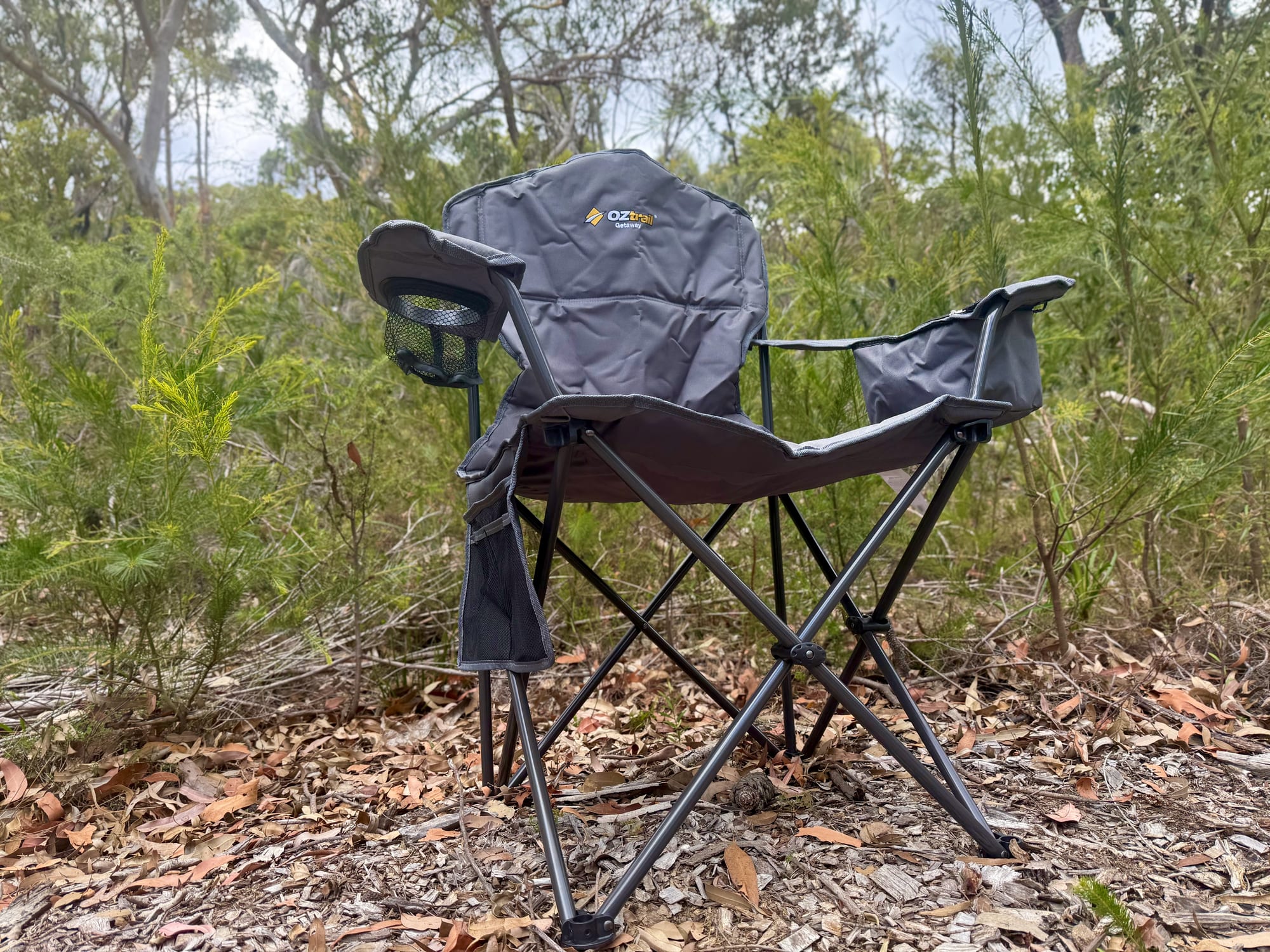 The OZtrail Getaway Chair from the side, showing the crossed steel legs of the frame