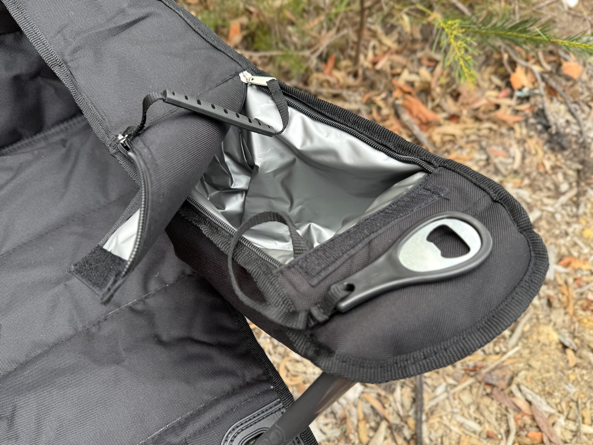 The arm cooler of the Getaway Deluxe open, with the bottle opener