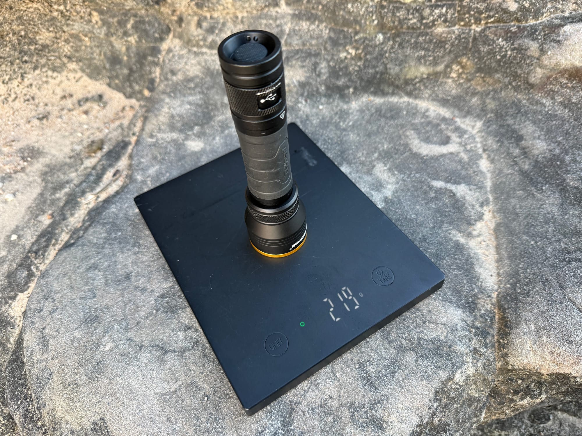 The OZtrail Lumos FR800 standing on a kitchen scale showing 219 g
