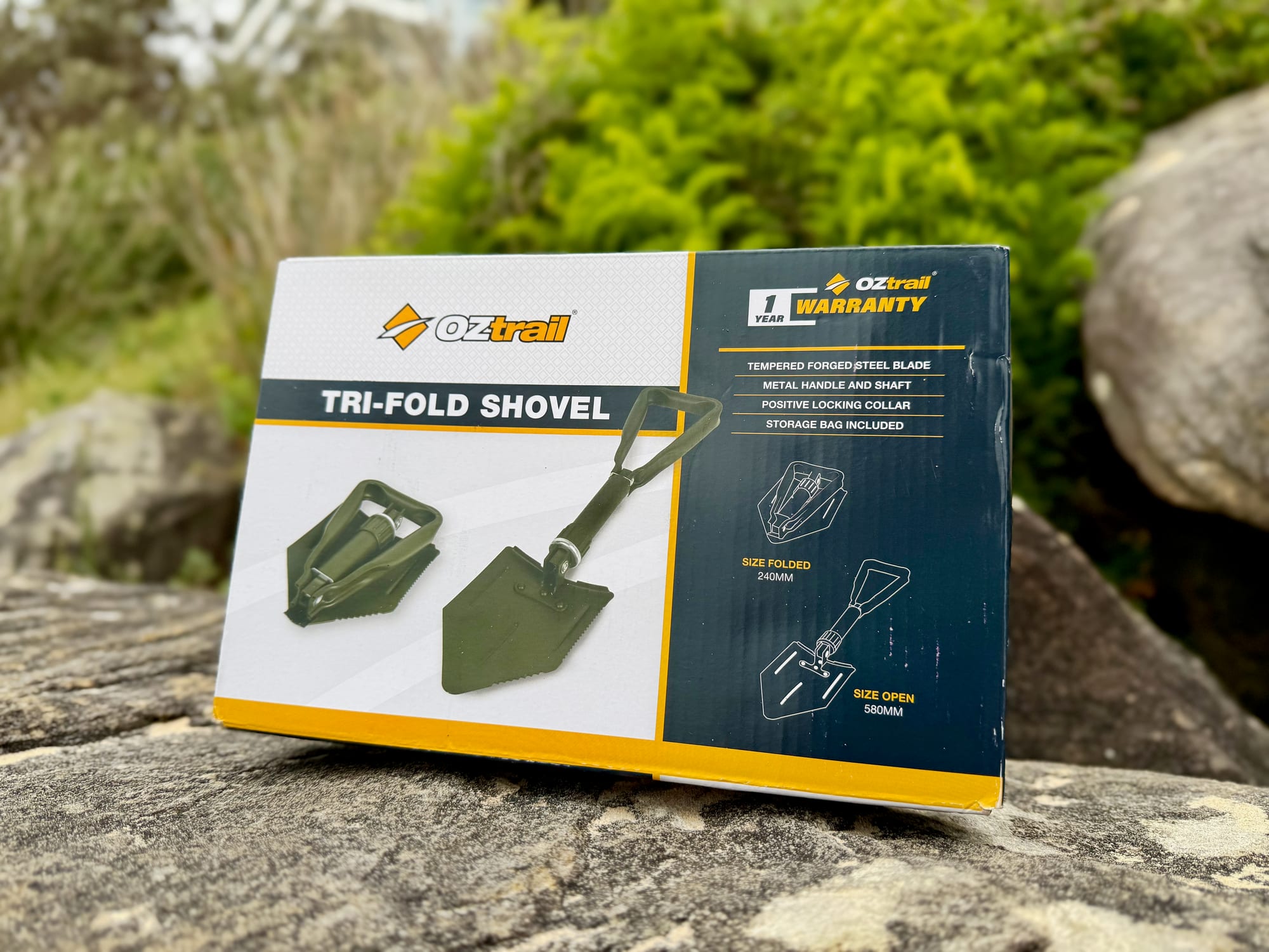 The OZtrail Tri-Fold Shovel box, listing a tempered forged steel blade, metal handle and shaft, locking collar and storage bag
