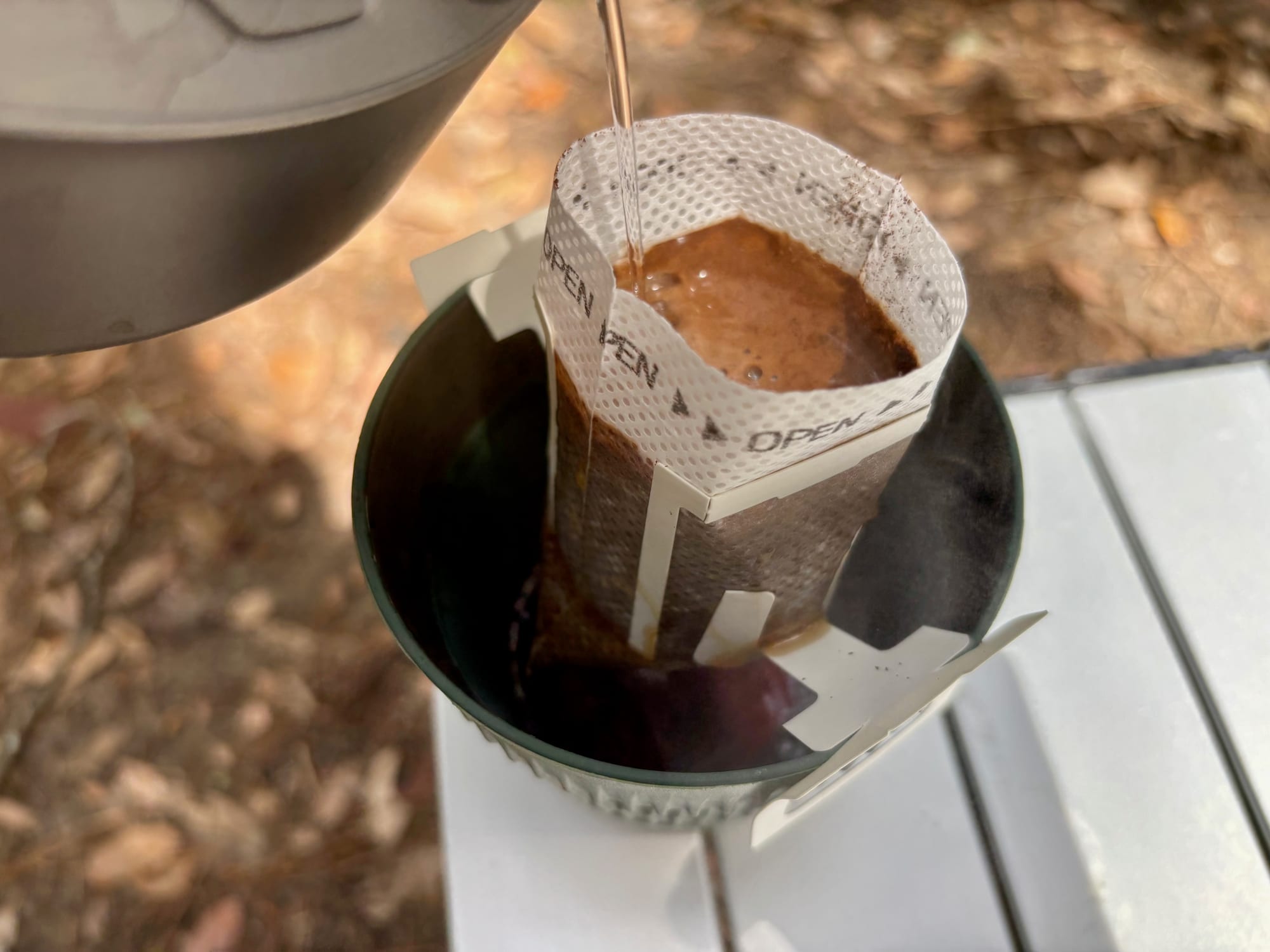 The coffee dripping through the filter bag into the mug