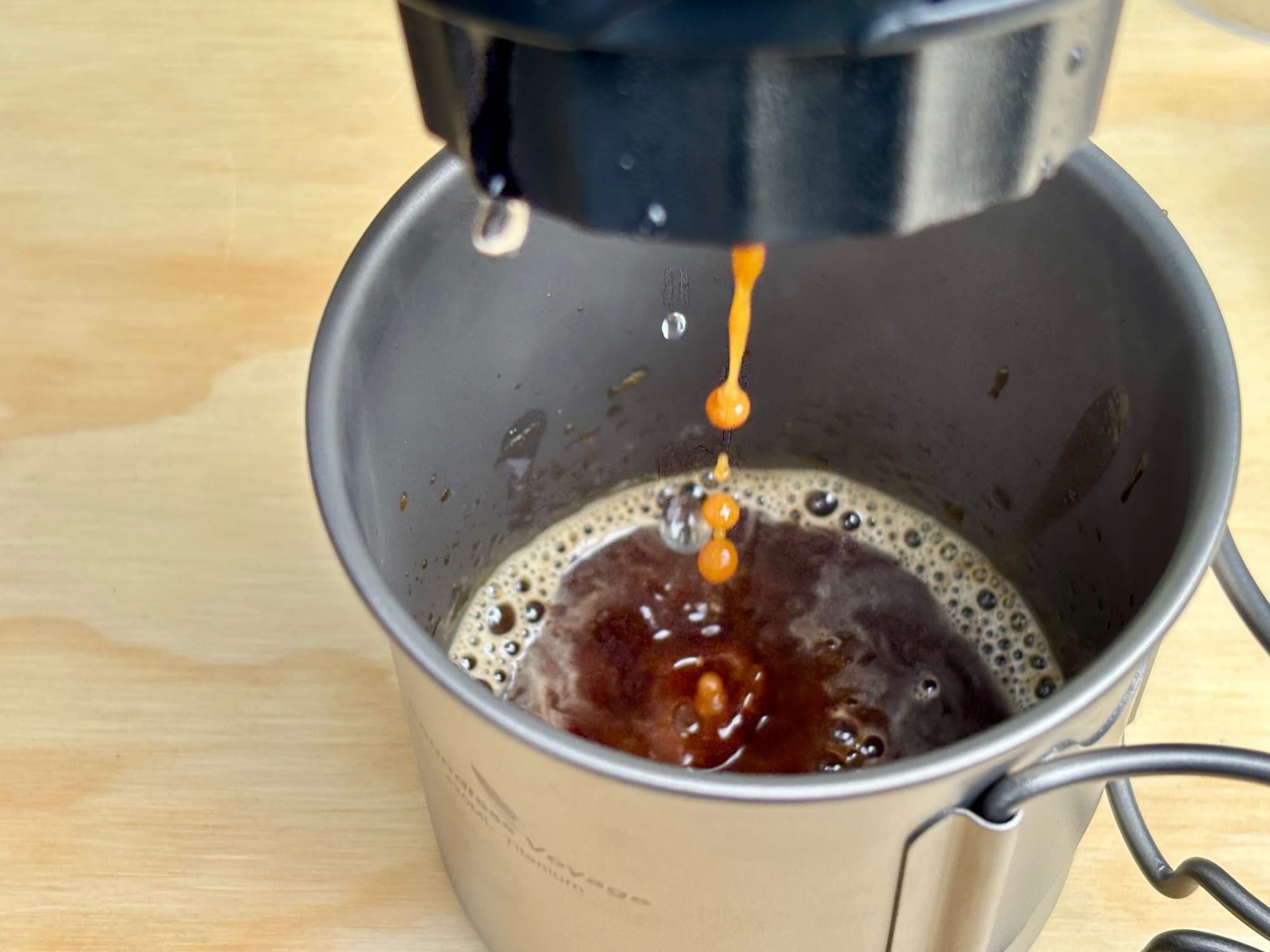 Espresso running out of the portable espresso machine into a titanium mug
