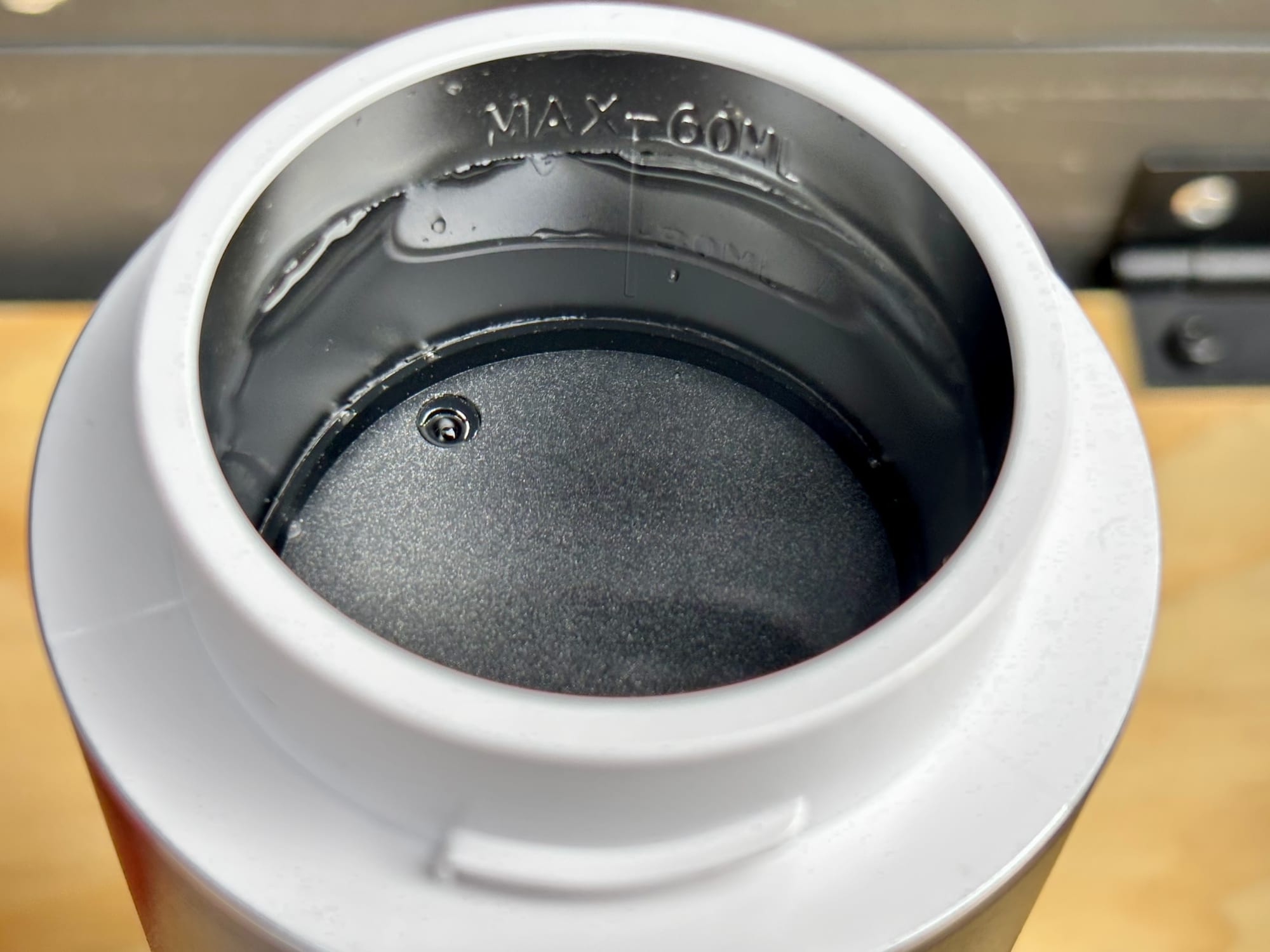 Looking into the water tank of the portable espresso machine, filled to the 60 ml mark