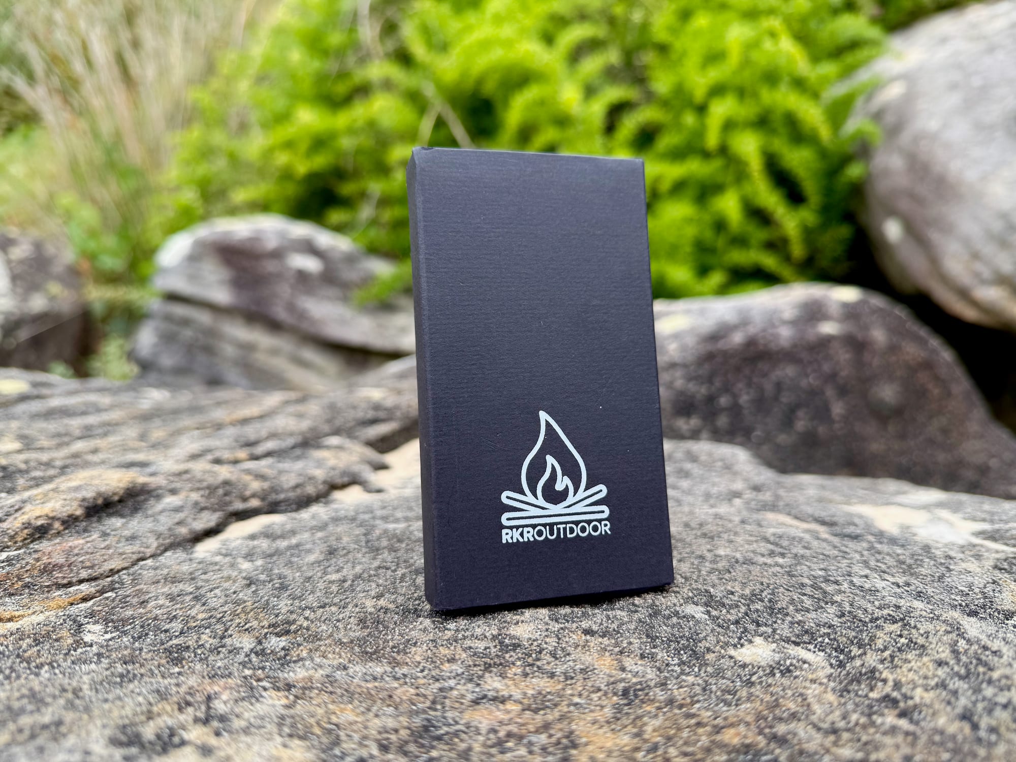 The RKR Outdoor box standing on a rock