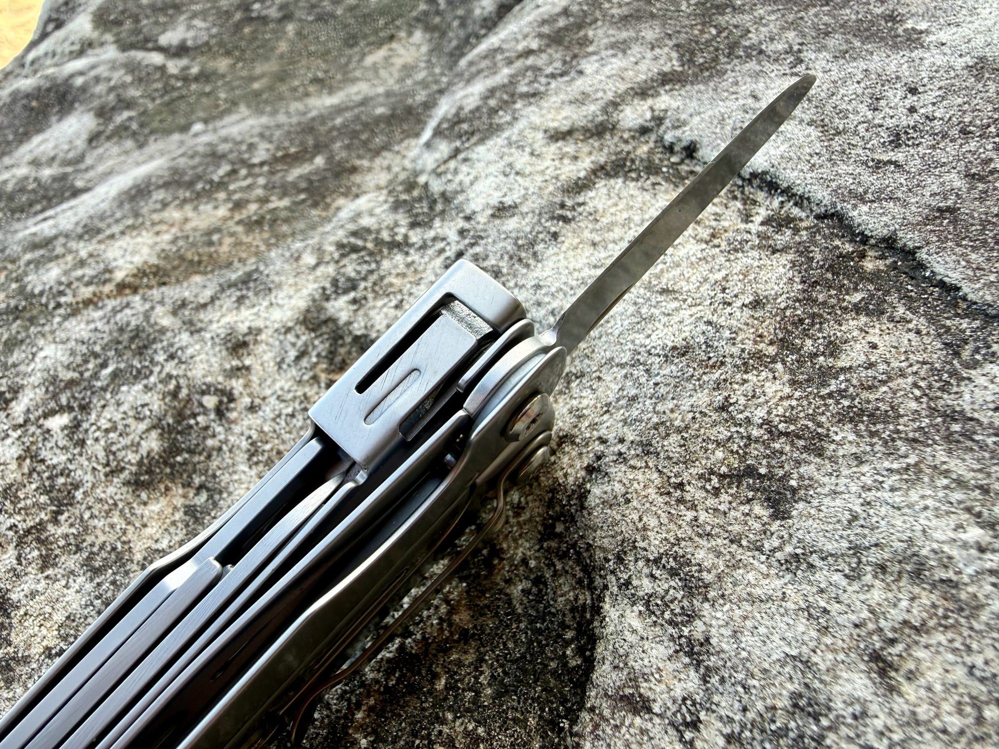 Close-up of the liner lock behind the open knife blade of the Roxon M2