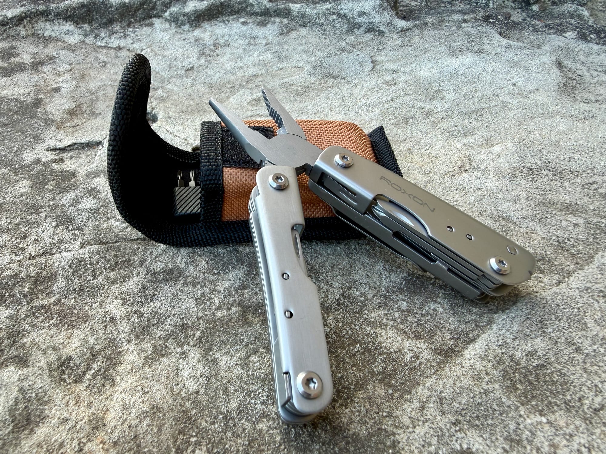 The Roxon M2 with its pliers open, lying against the belt pouch