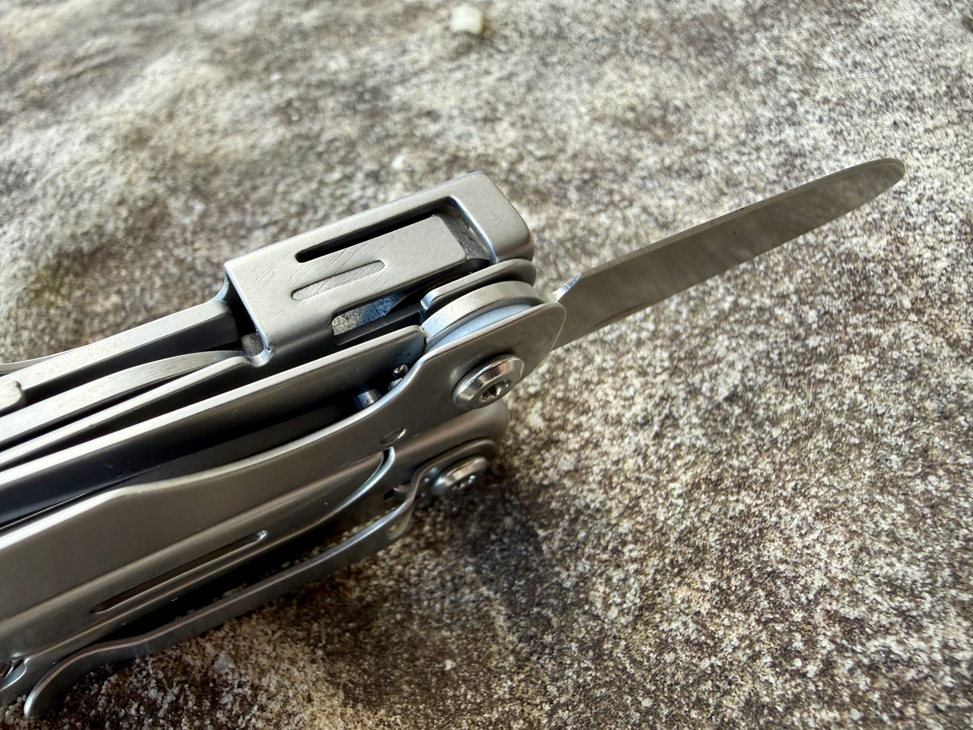 The pocket clip on the handle of the Roxon M2, with the knife folded out