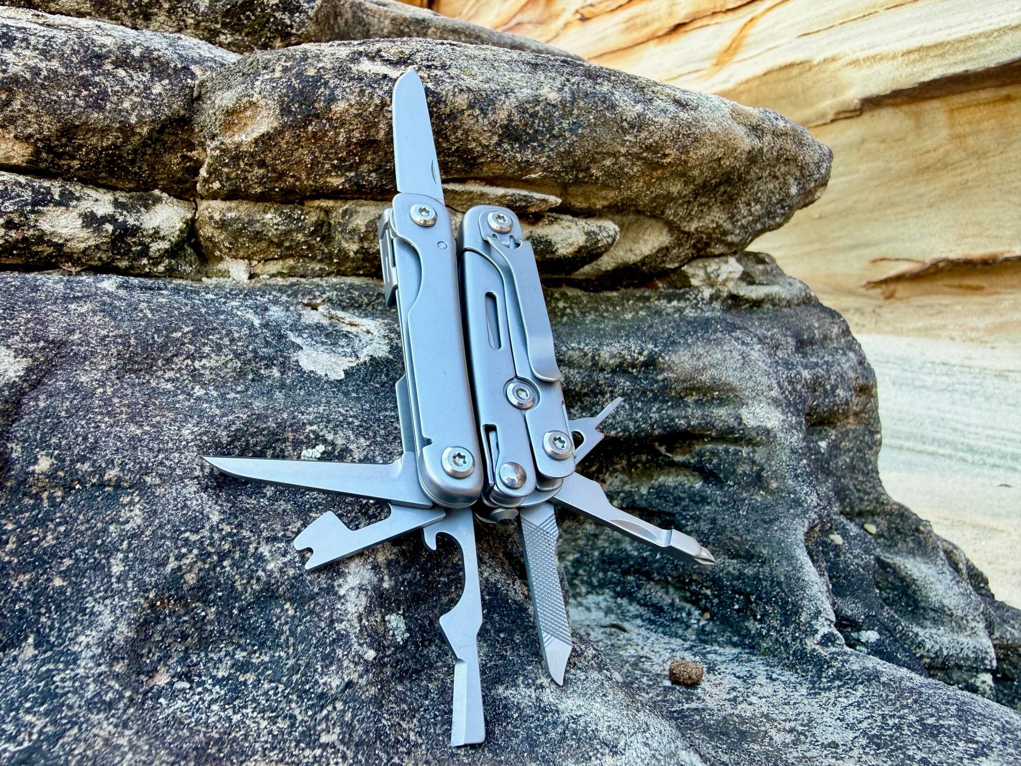 The Roxon M2 standing against a rock with its knife, file, screwdrivers and openers folded out