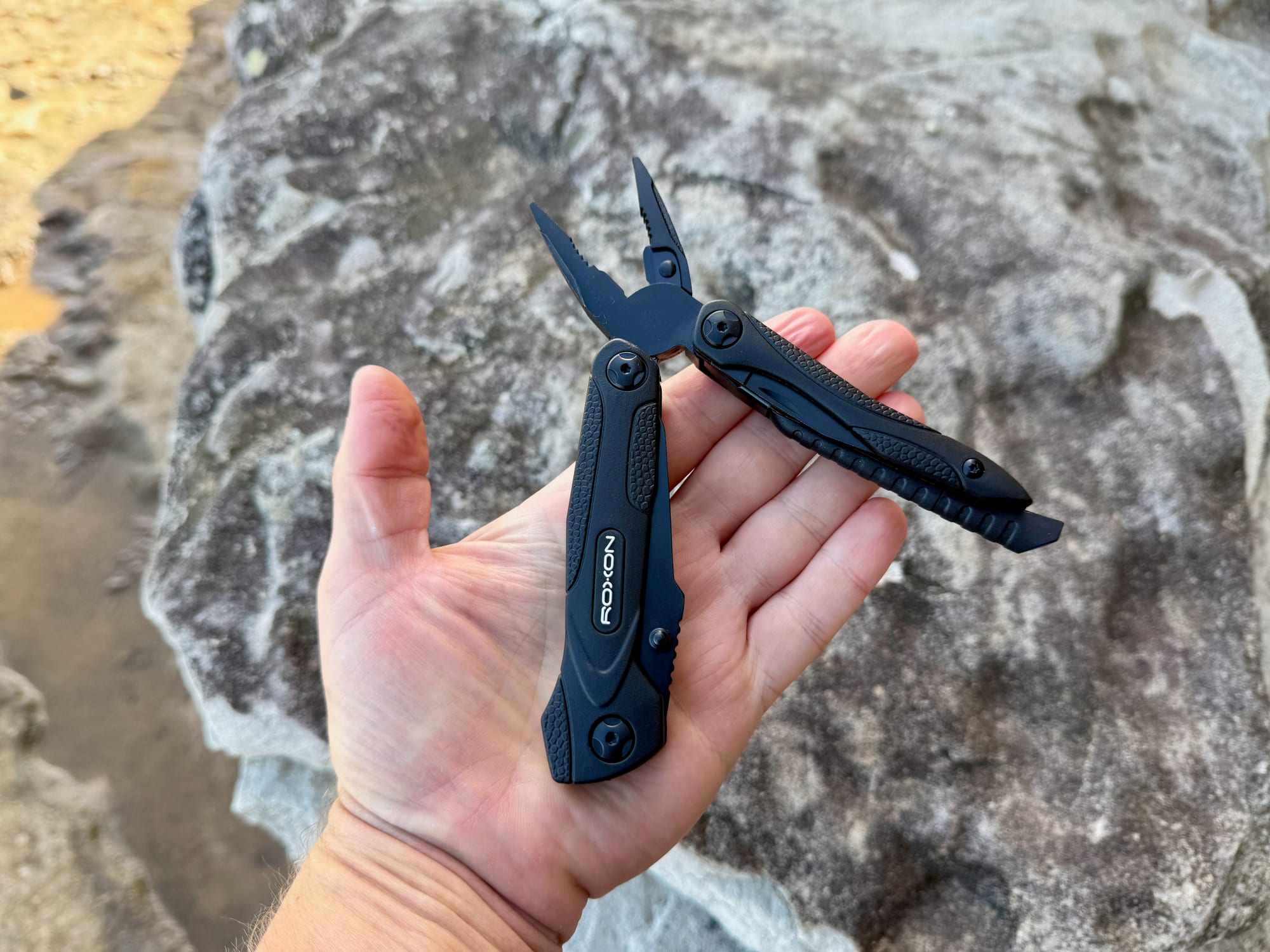 The Roxon Spark in the palm of a hand with the pliers open
