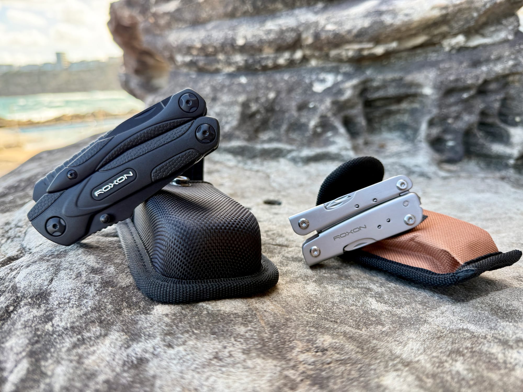 The black Roxon Spark and the silver Roxon M2 side by side with their pouches