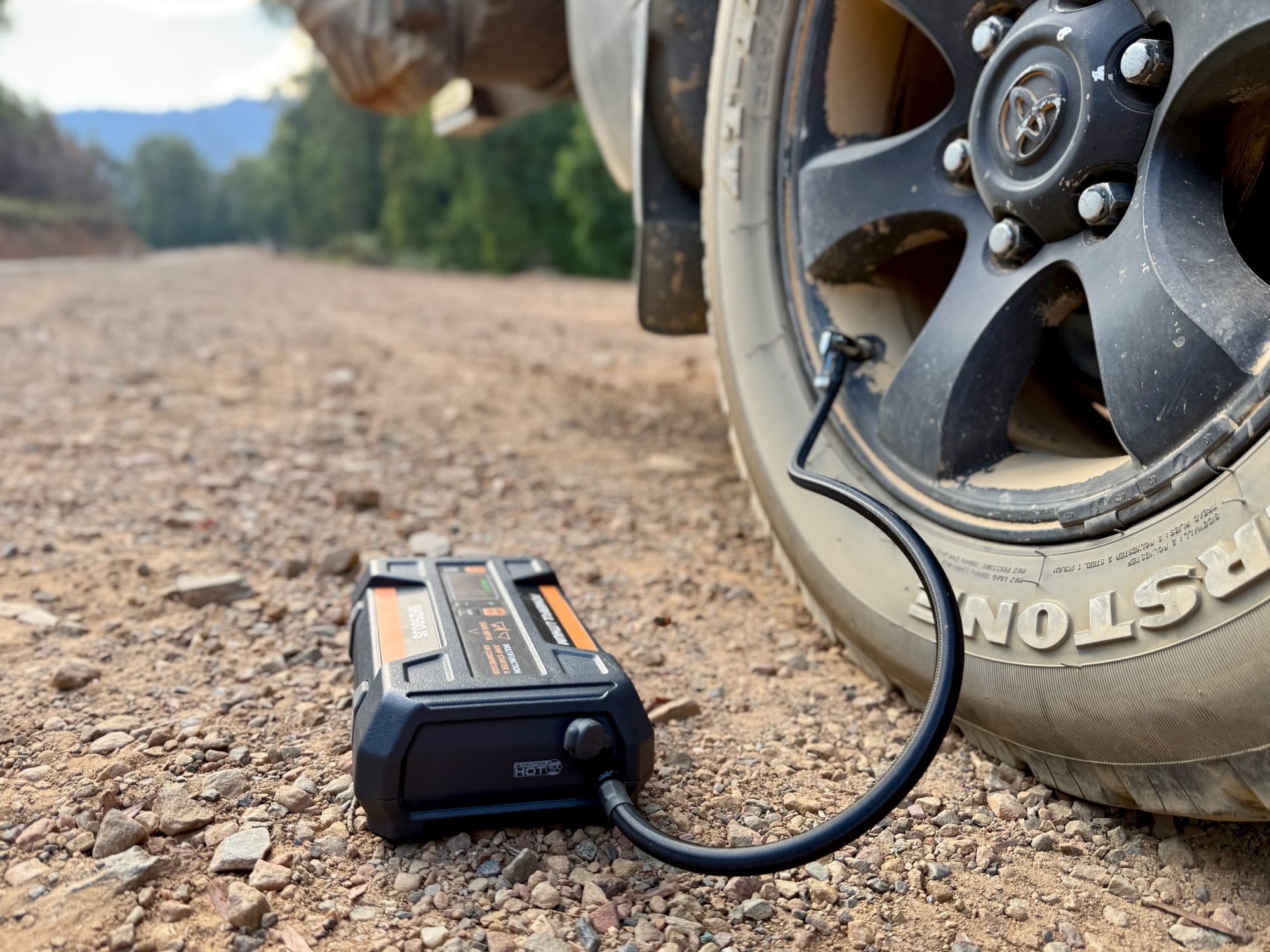The San Hima pumping up a tyre on the gravel shoulder of a mountain road