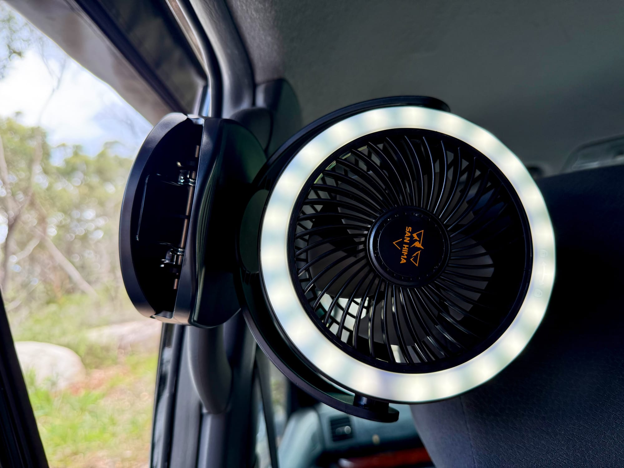 The San Hima clip fan clamped in the car with its ring light on