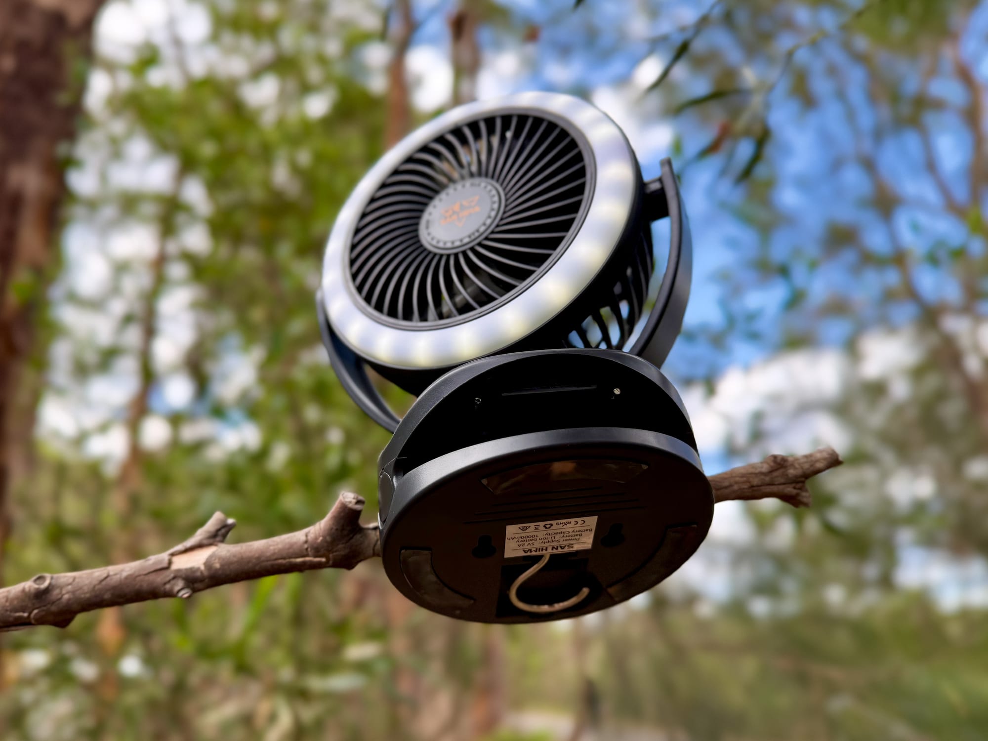 The San Hima clip fan clamped onto a thin branch with its ring light on