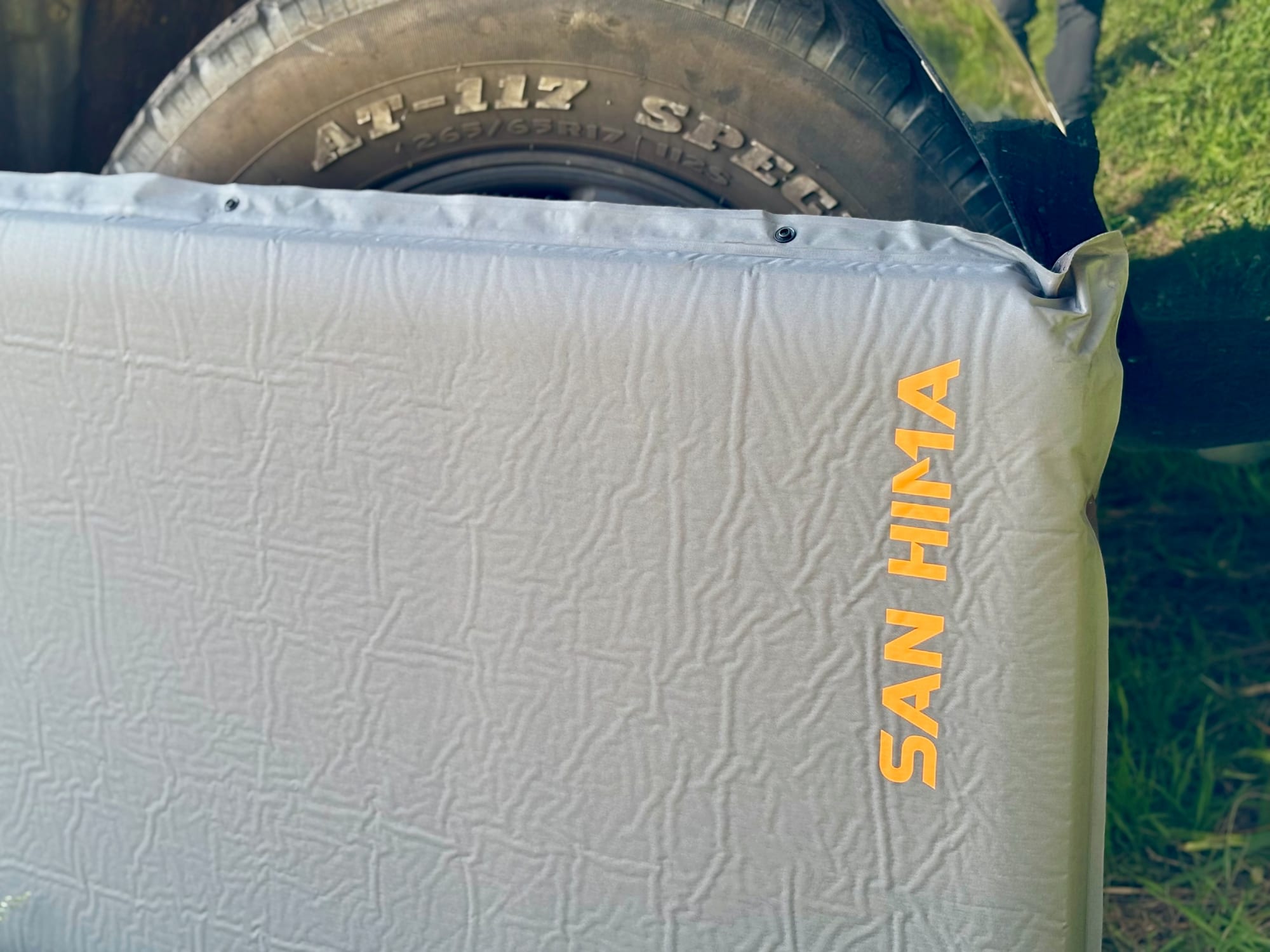 The San Hima self-inflating mattress standing against the wheel of our 4WD