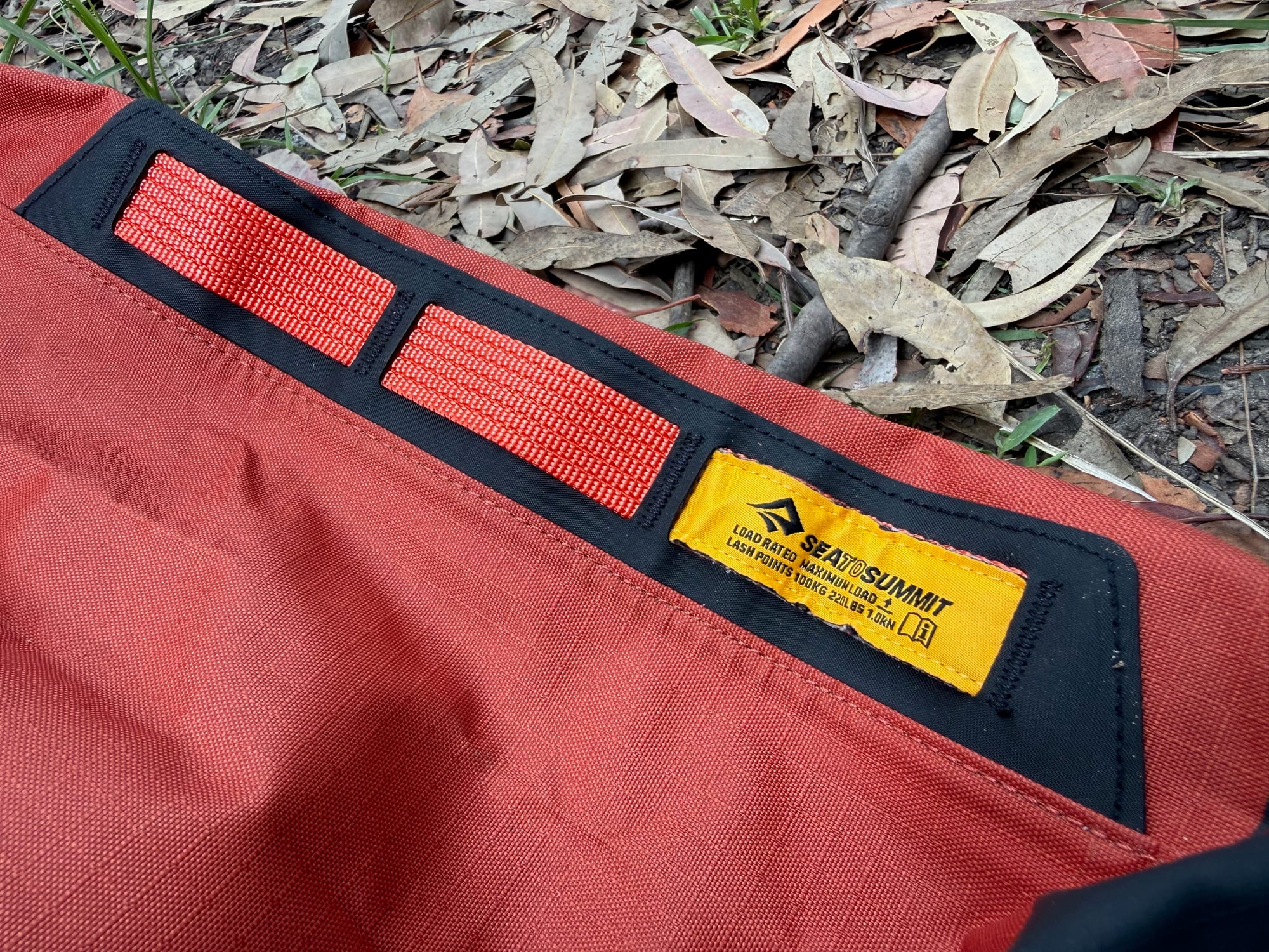 The webbing lash points on the Big River dry bag, with the load rating label