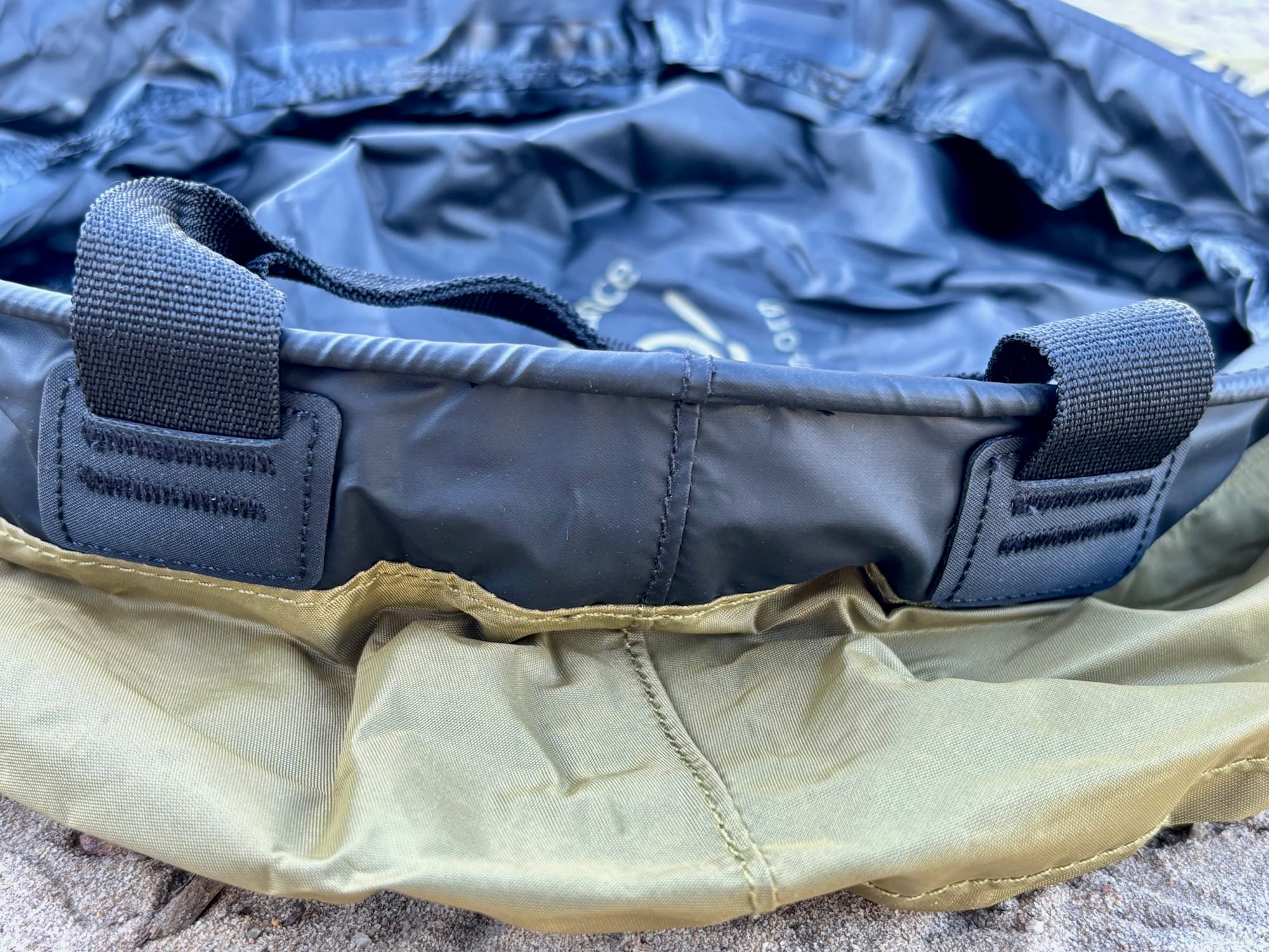 Close-up of a webbing handle stitched onto the black rim of the Sea to Summit kitchen sink
