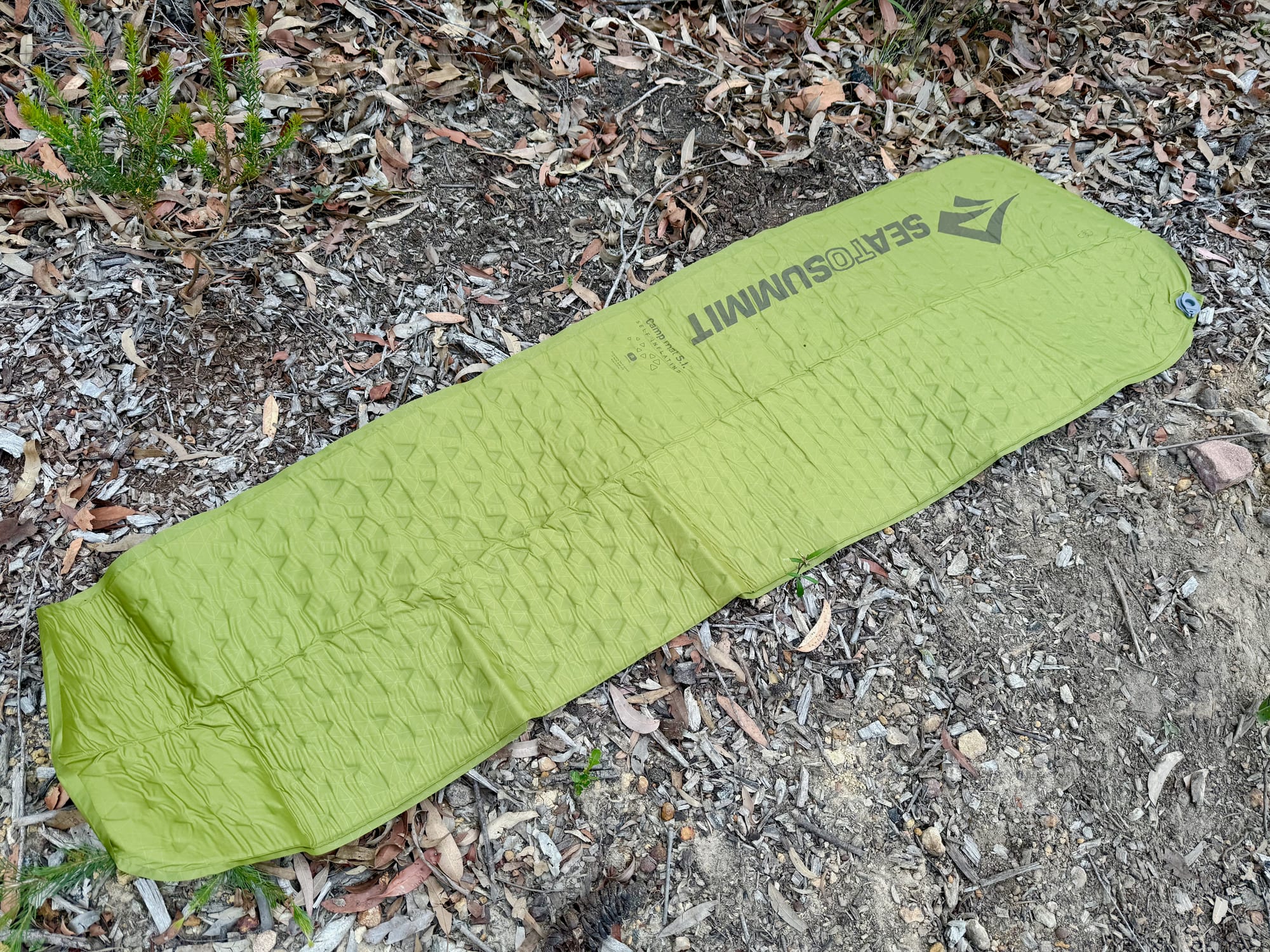 The Sea to Summit Camp Mat SI unrolled on the ground before inflating