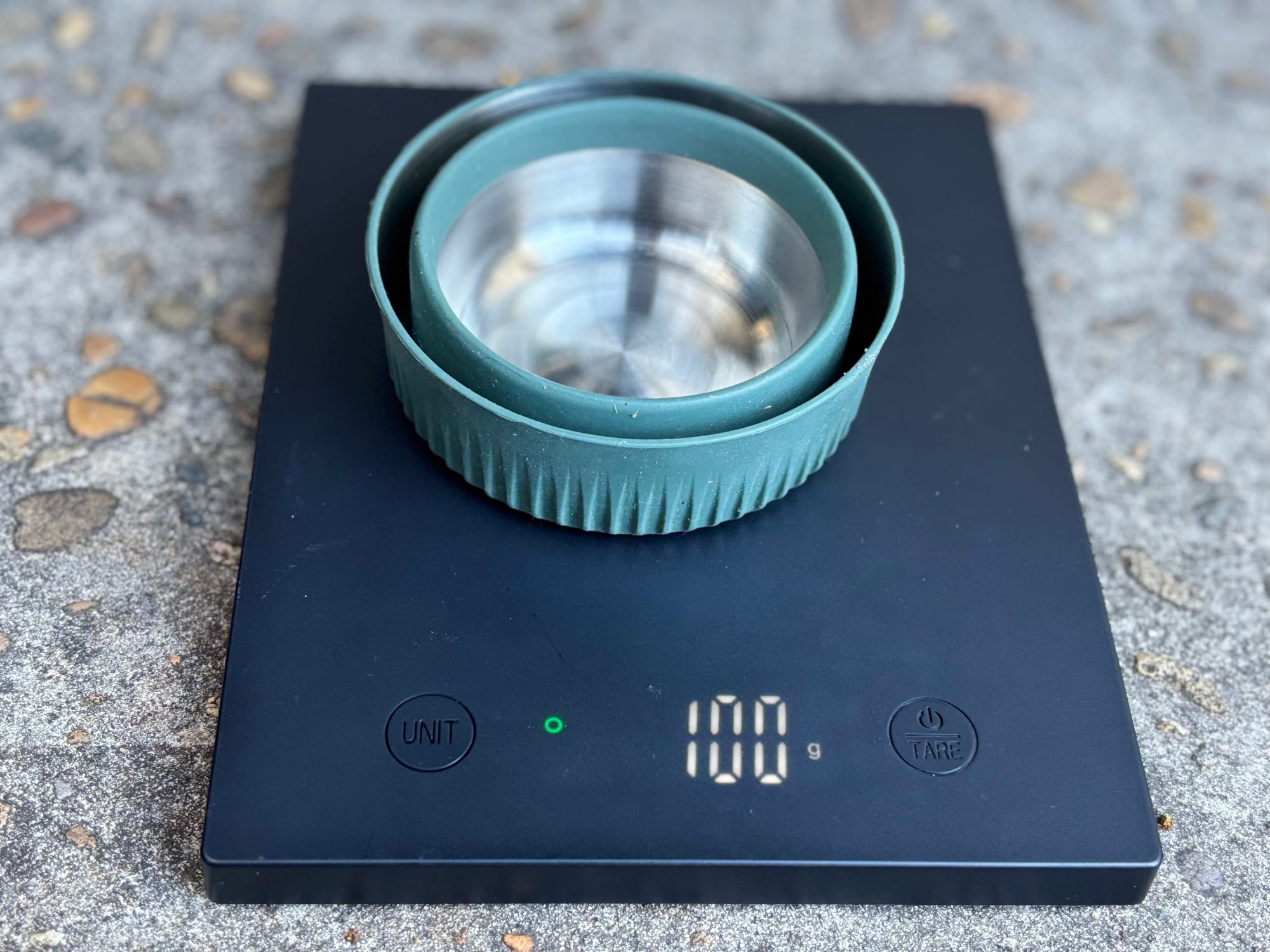 The Detour collapsible mug collapsed on a digital scale showing 100 grams