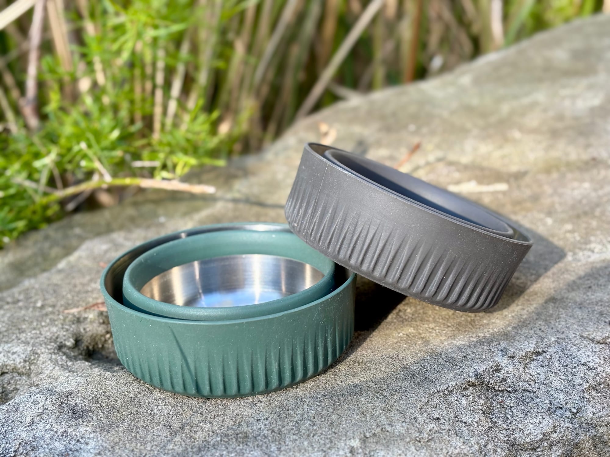 Two Sea to Summit Detour mugs collapsed flat on a rock, one green and one charcoal