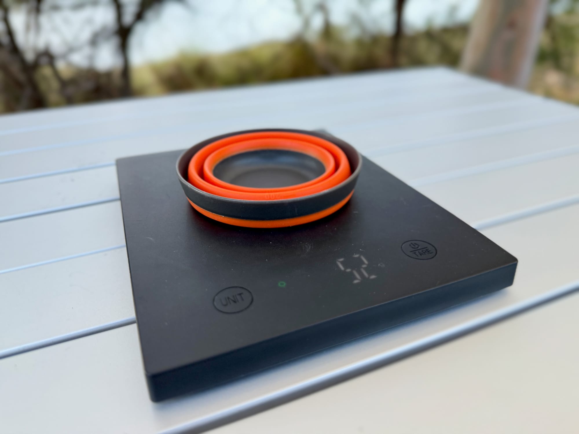 The collapsed Frontier collapsible cup on a digital scale showing 52 grams