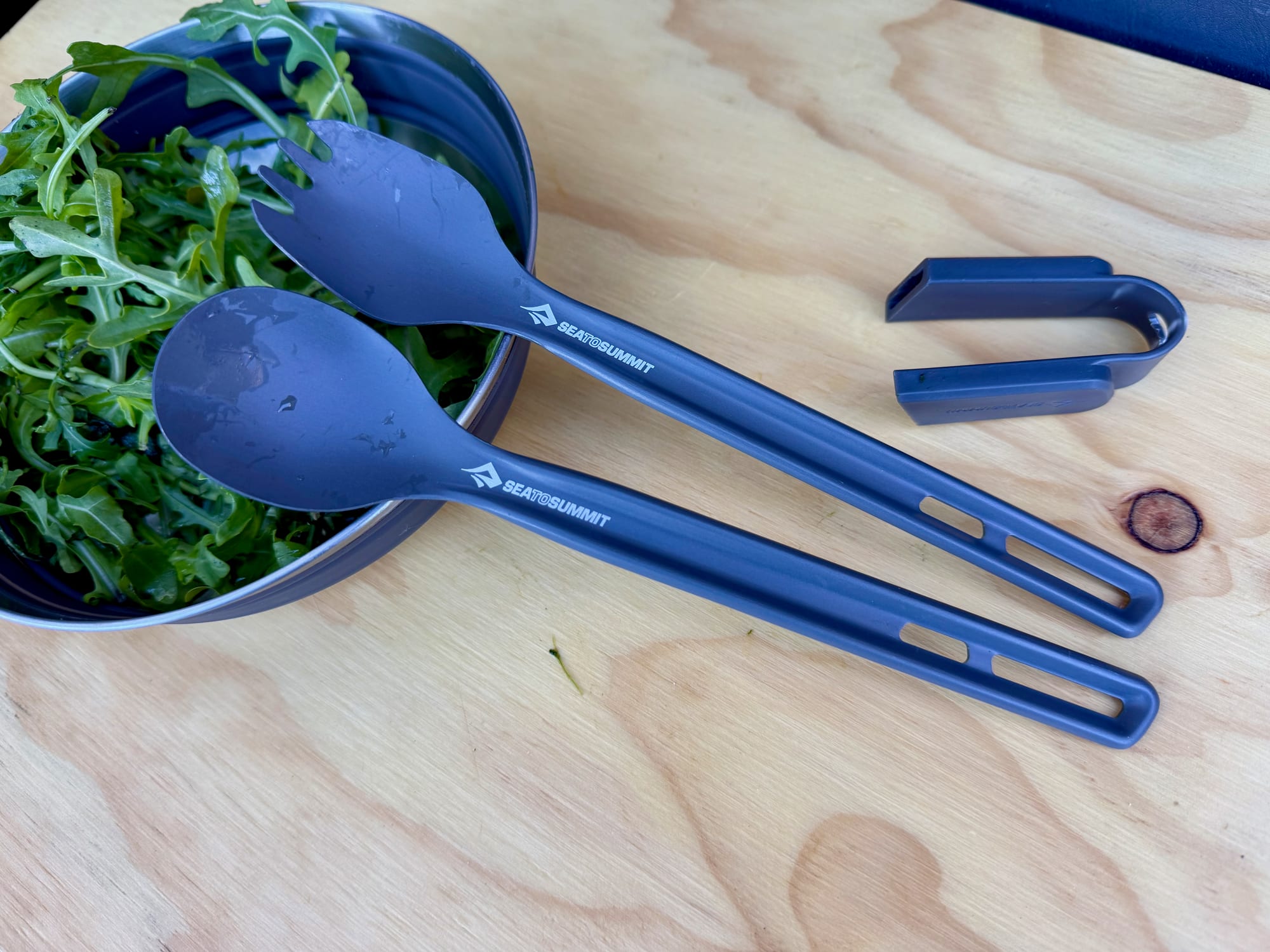 The long-handled spoon and spork side by side, with the clip next to them