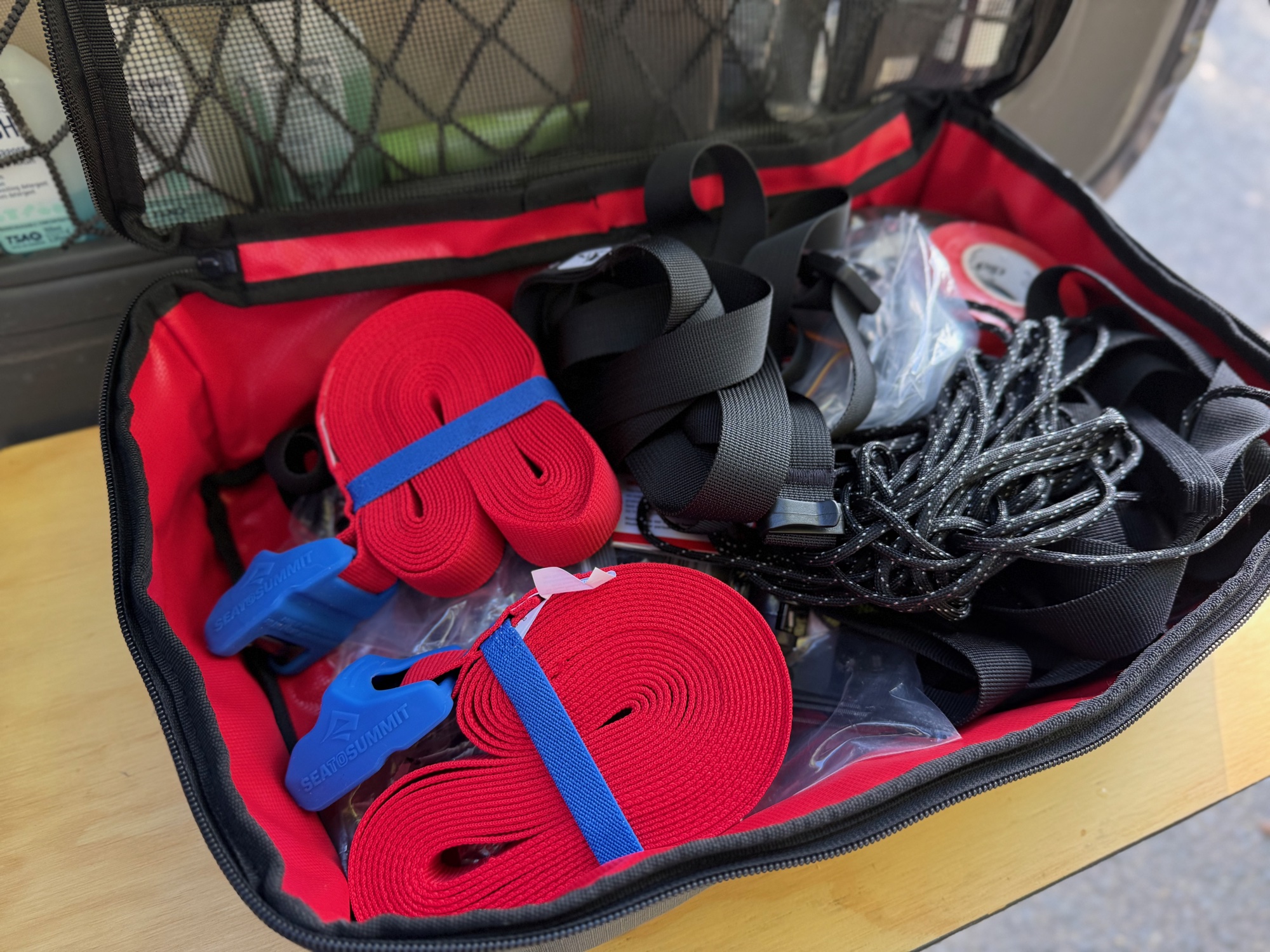 Two rolled Sea to Summit tie downs in a Kaon storage bag with other straps and ropes