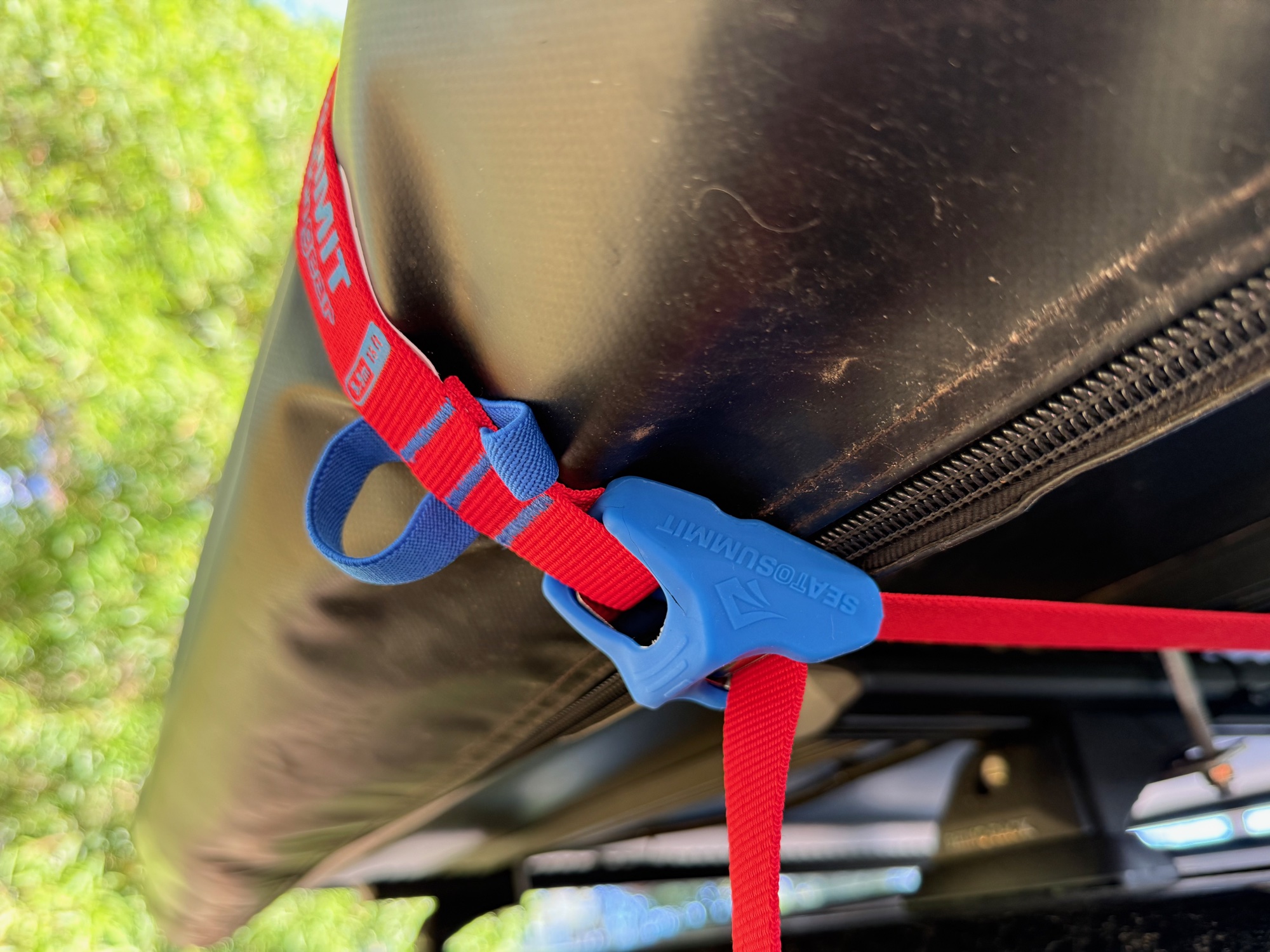 The cam buckle of a Sea to Summit tie down pulled tight on the awning bag