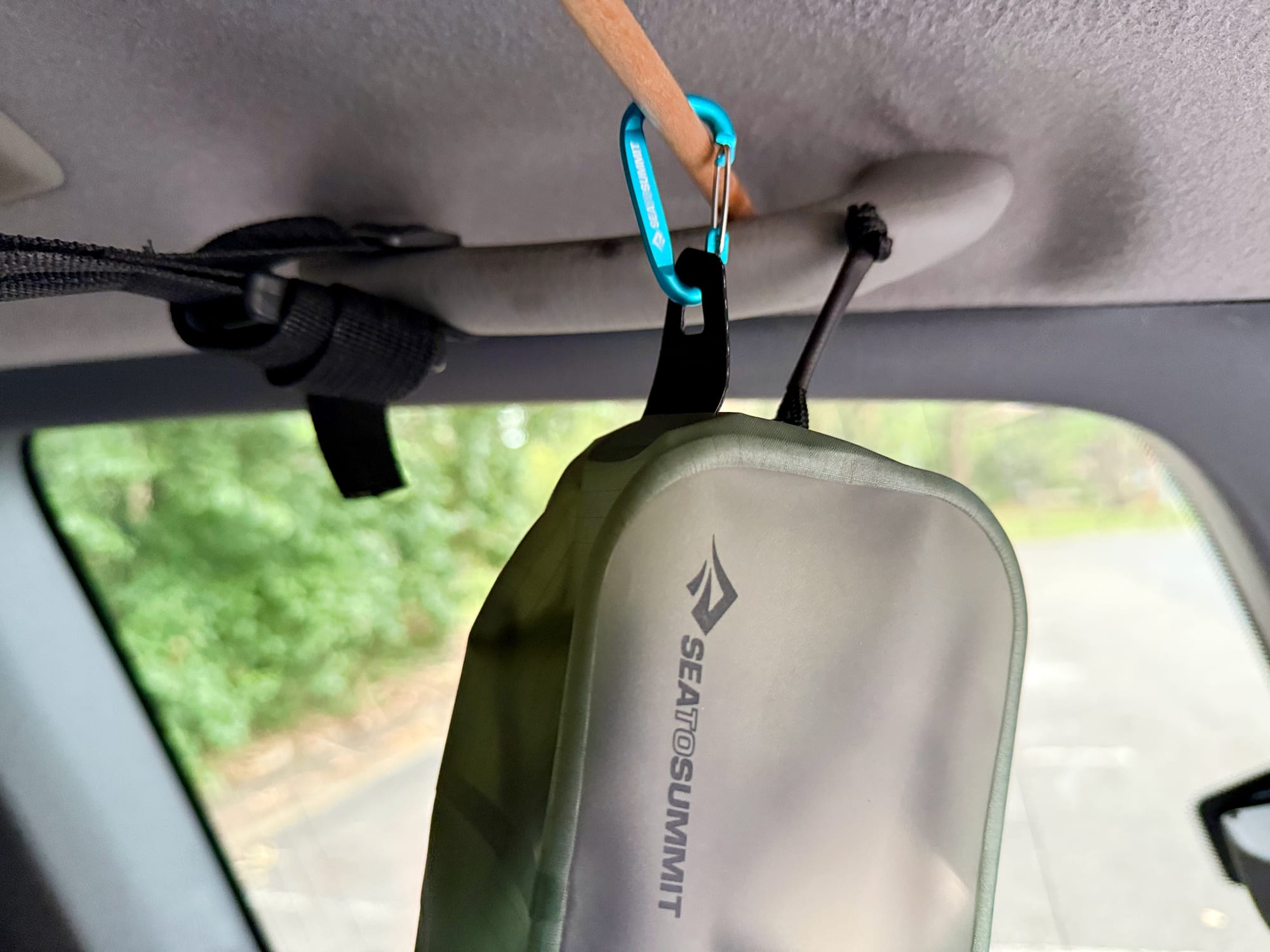 The extra small cube hanging from the grab handle inside the car with a carabiner