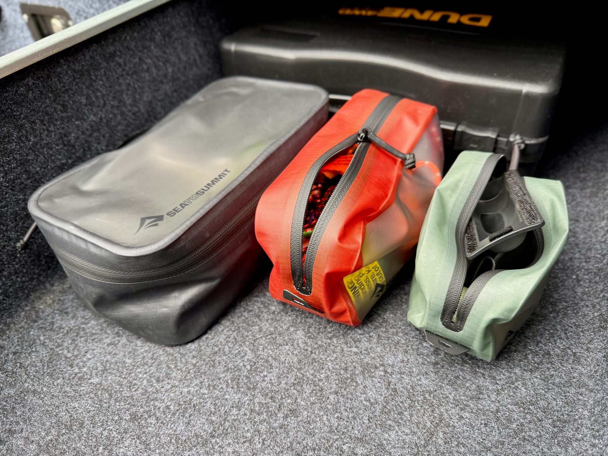 The three packing cubes side by side in the boot of the car