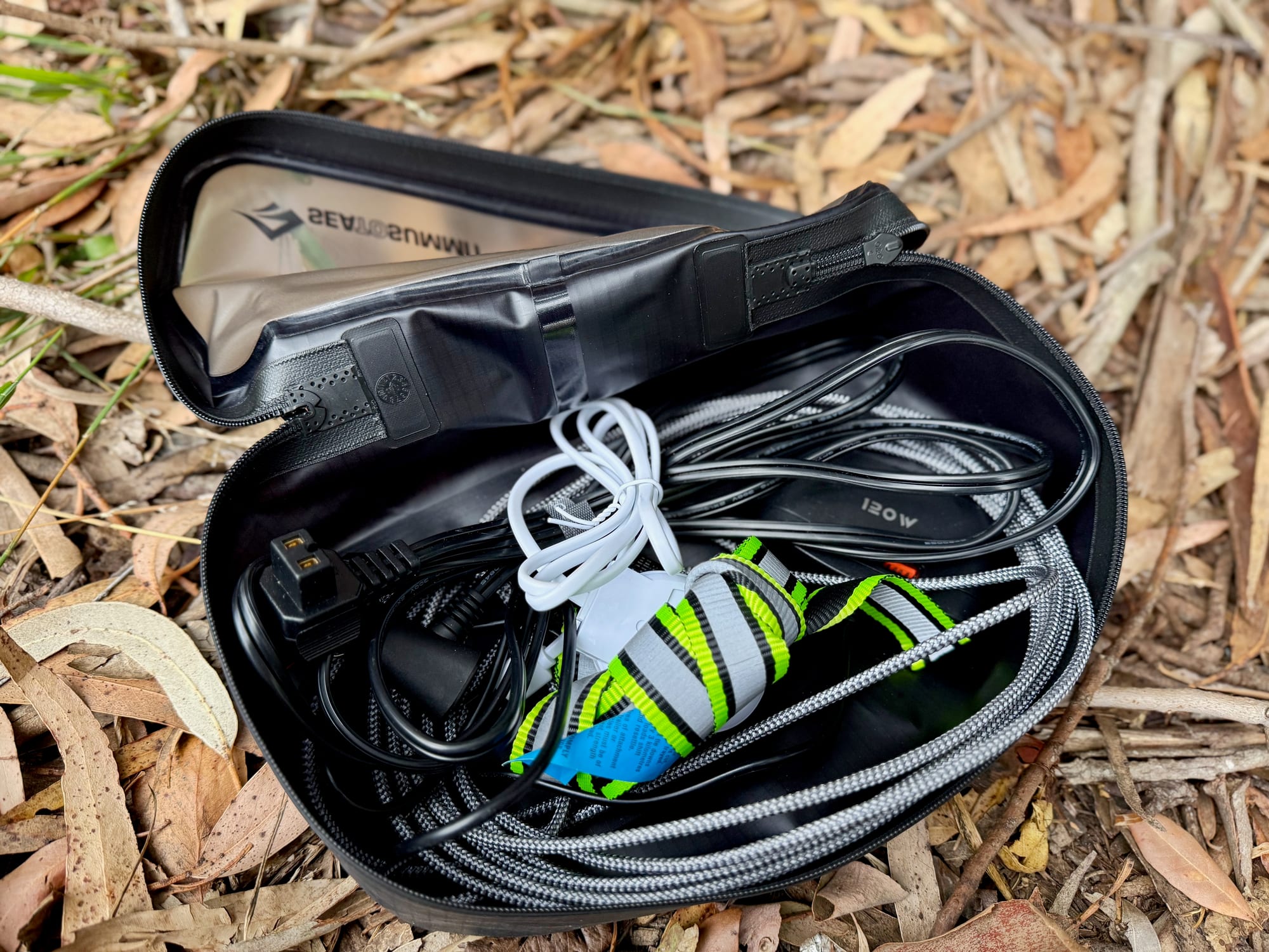 The medium cube open, with charging cables and a head torch inside