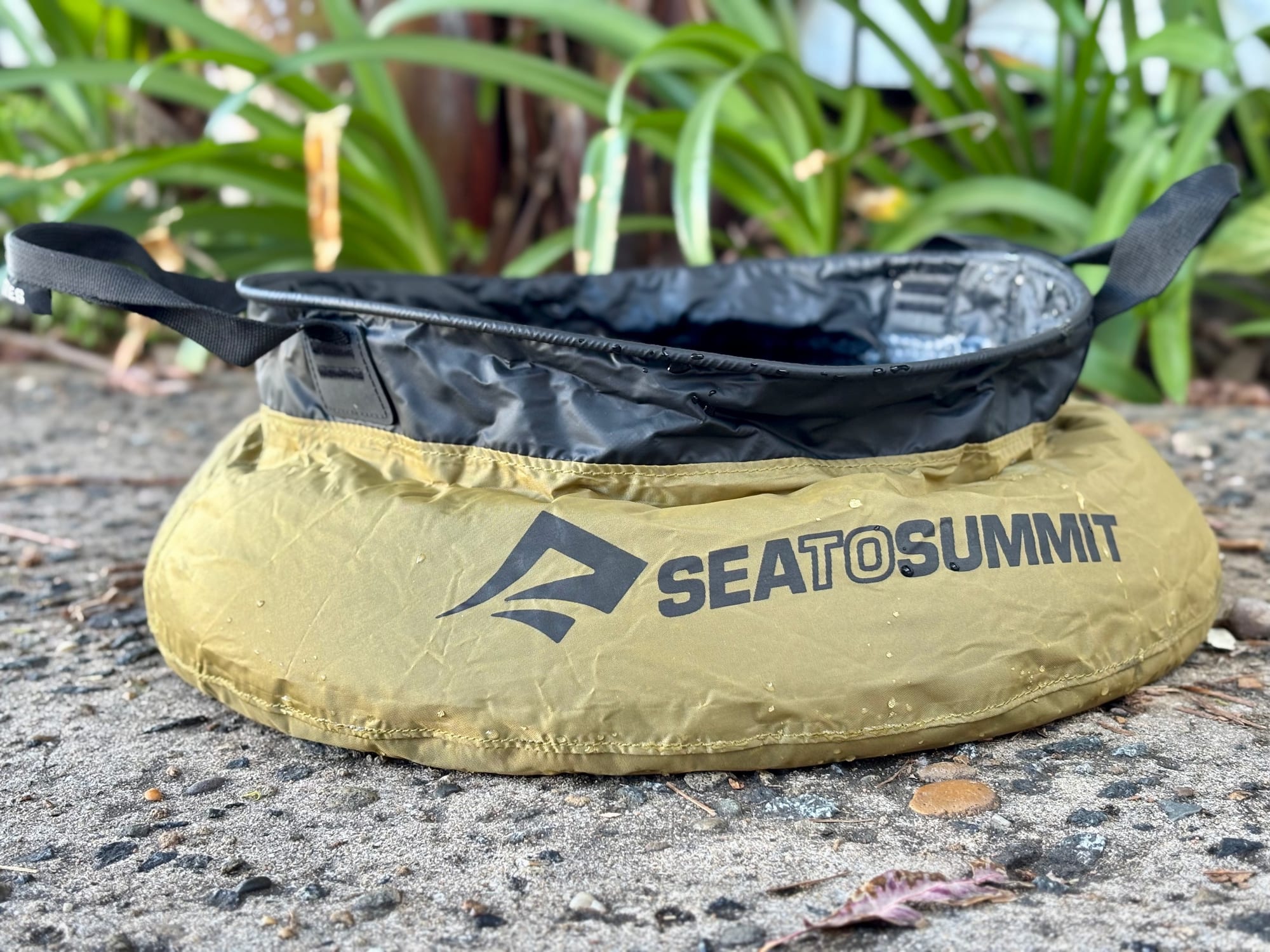 The Sea to Summit Kitchen Sink full of water, seen from the side at ground level