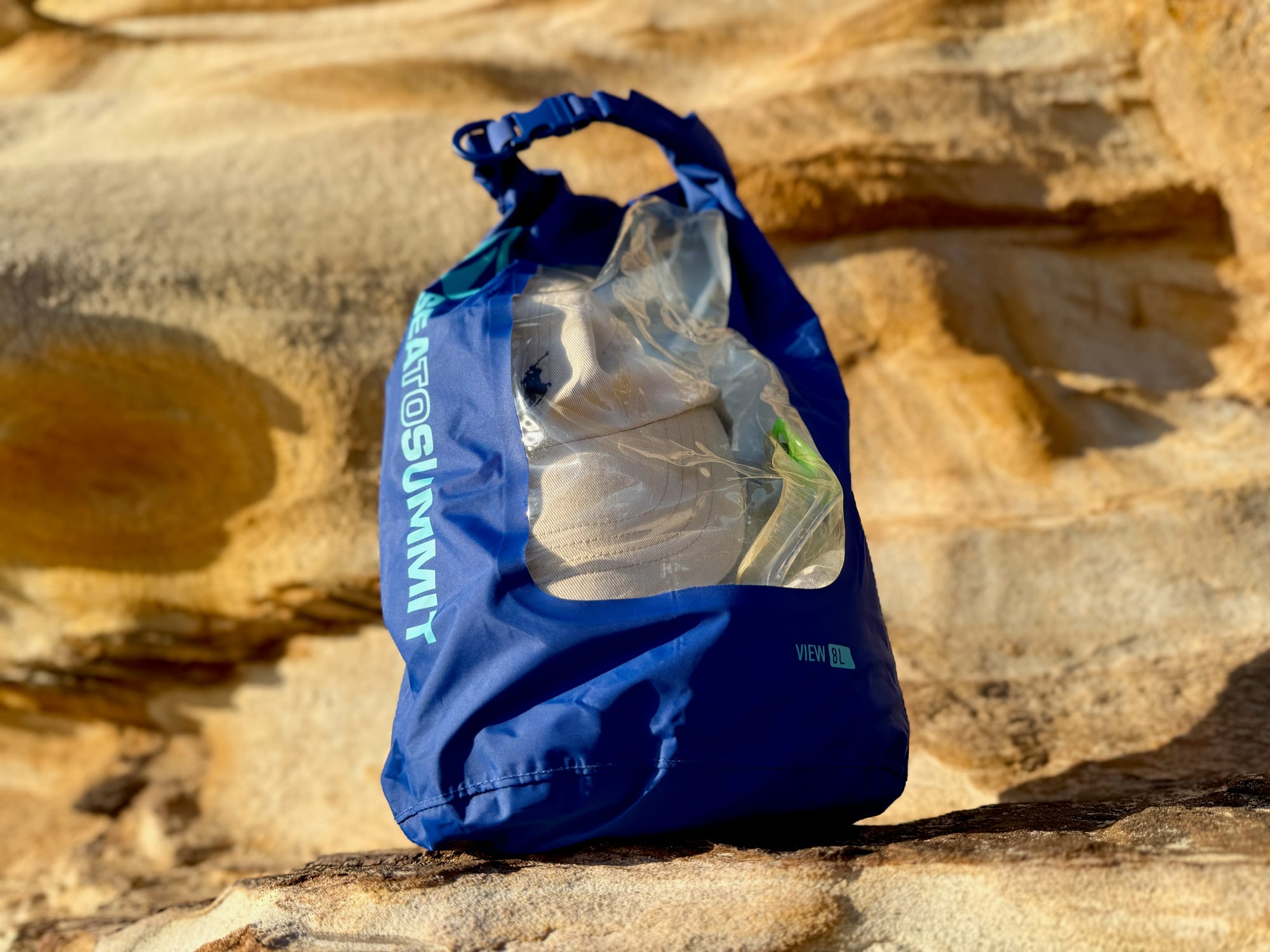 The Dry Bag View packed and standing, with its contents visible through the clear window