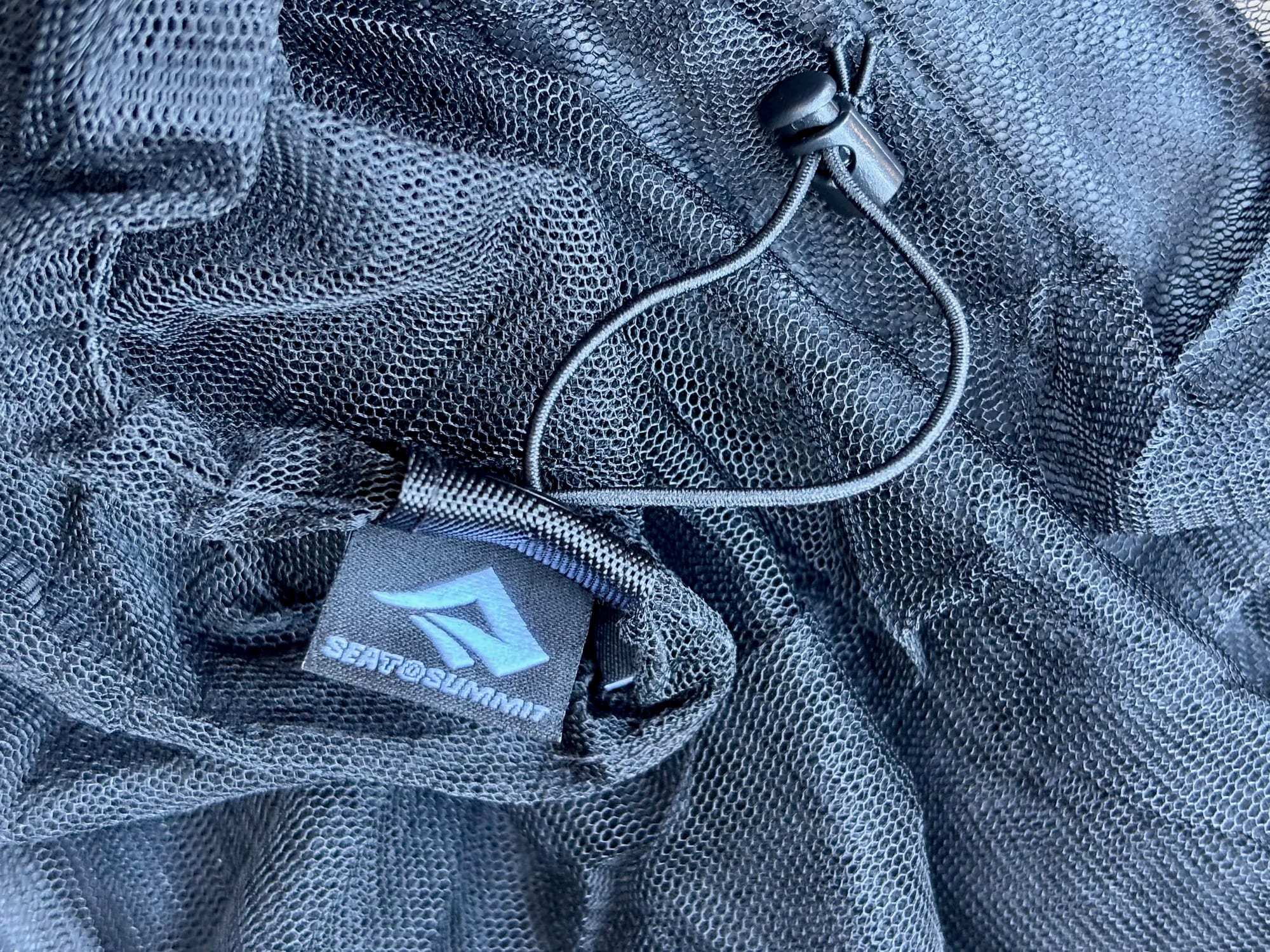 The elastic drawcord, cord lock and Sea to Summit tag on the hem of the head net