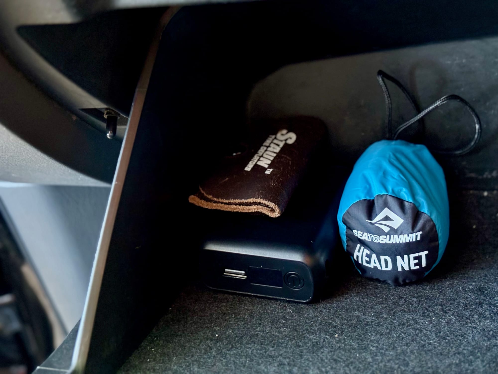 The Sea to Summit Head Net in its stuff sack, stored in a compartment in the car