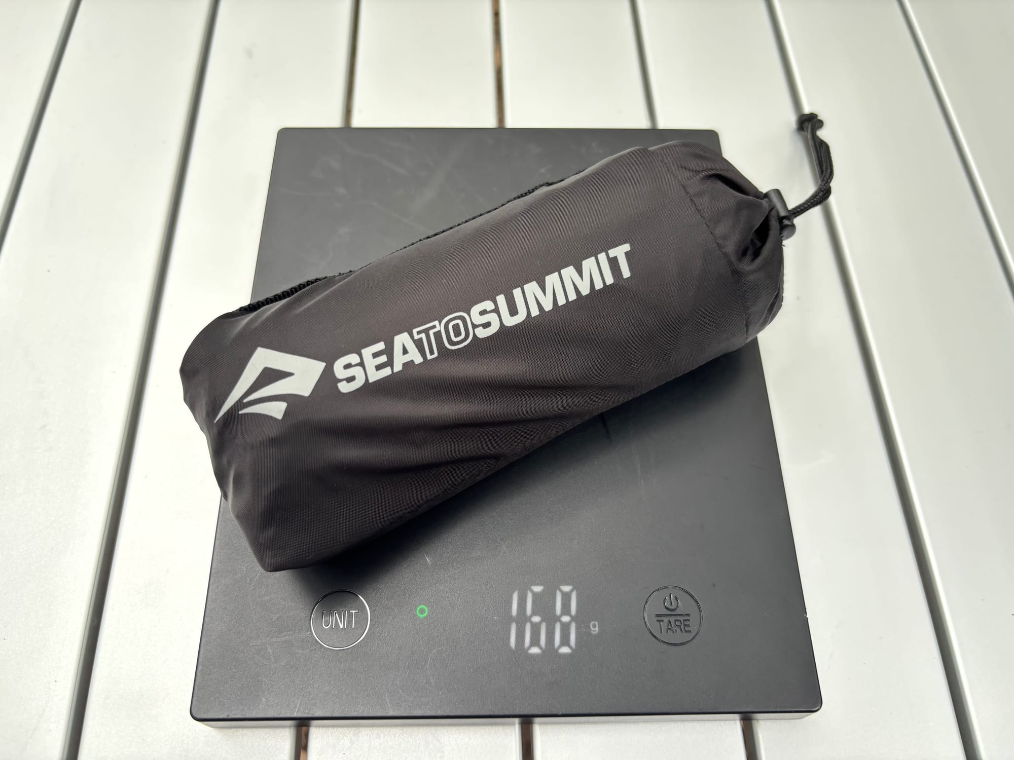 The Sea to Summit Pocket Umbrella in its pouch on the scale at 168 g