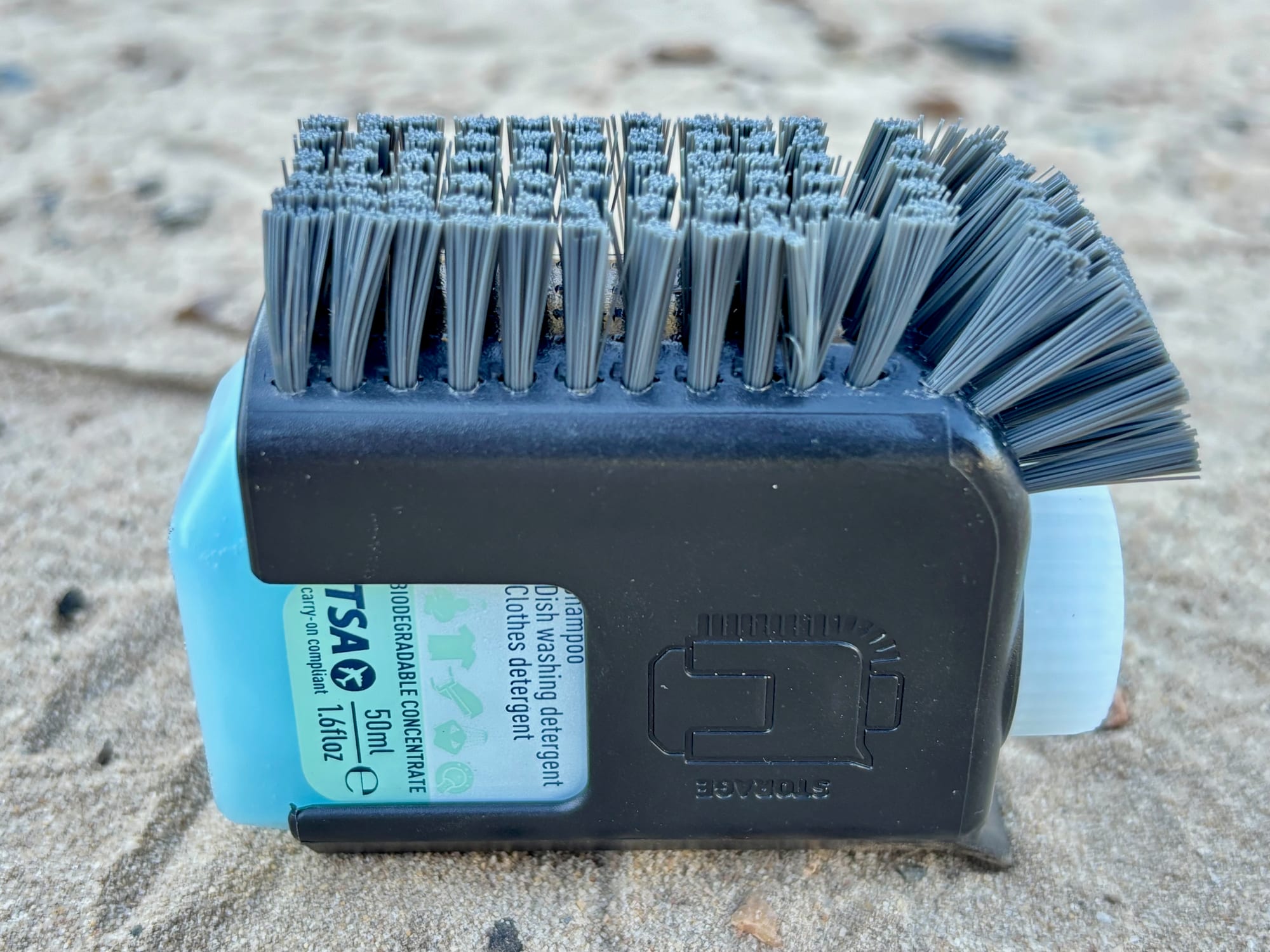 The back of the Sea to Summit Pot Scrubber with the blue bottle of Wilderness Wash clipped in