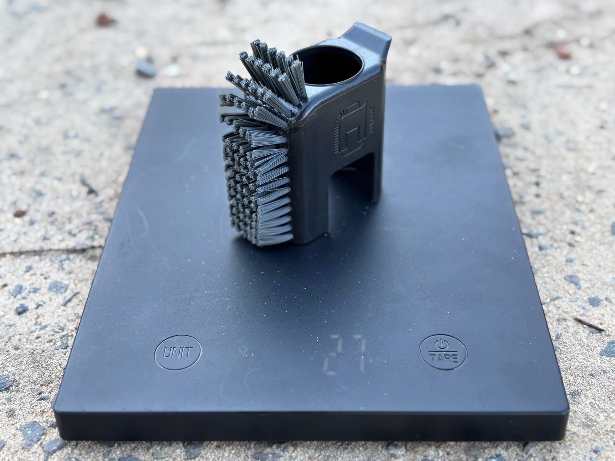 The Sea to Summit Pot Scrubber on a scale without its bottle, showing the empty holder
