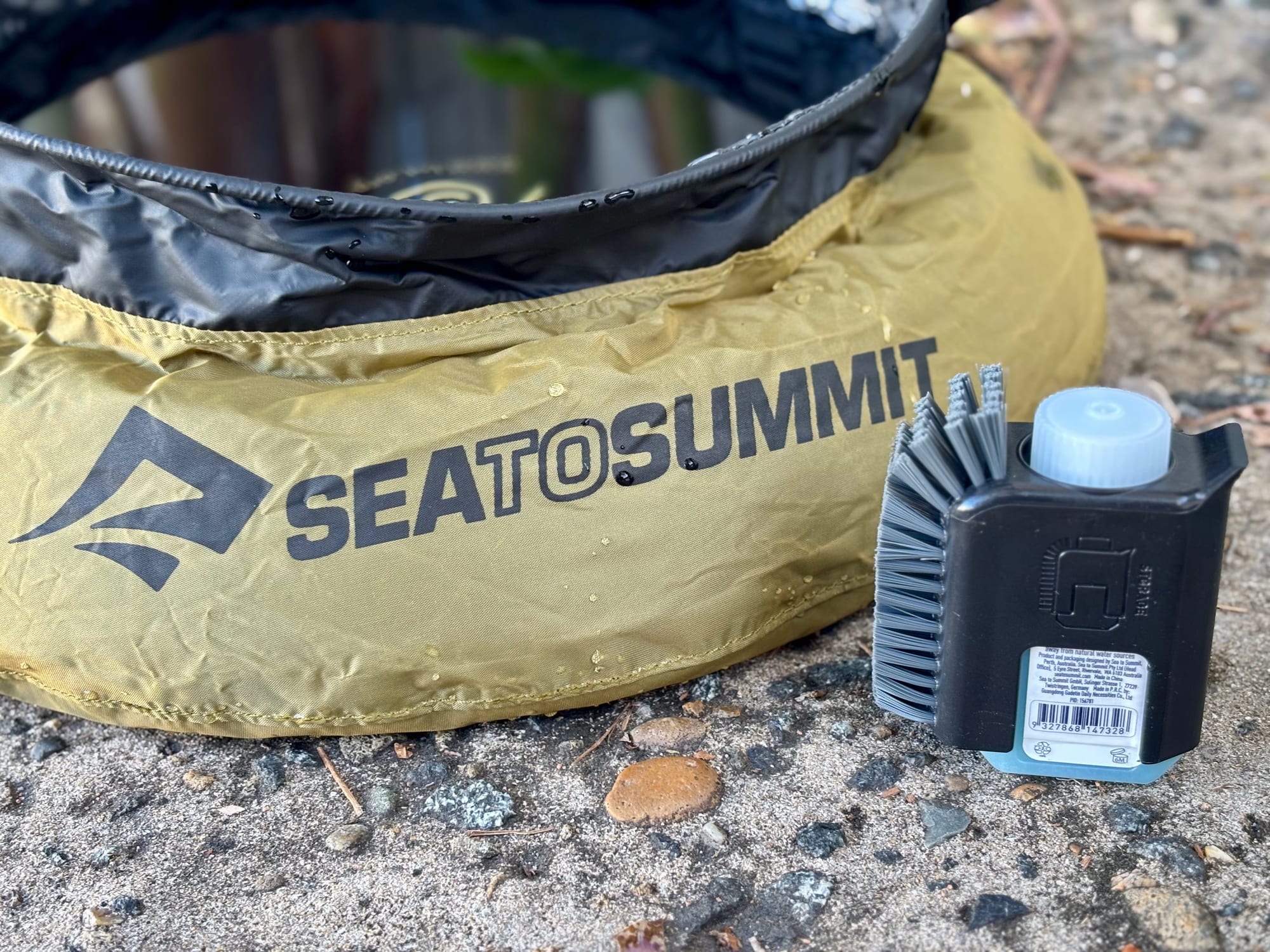 The Sea to Summit Pot Scrubber and soap next to the olive Sea to Summit Kitchen Sink