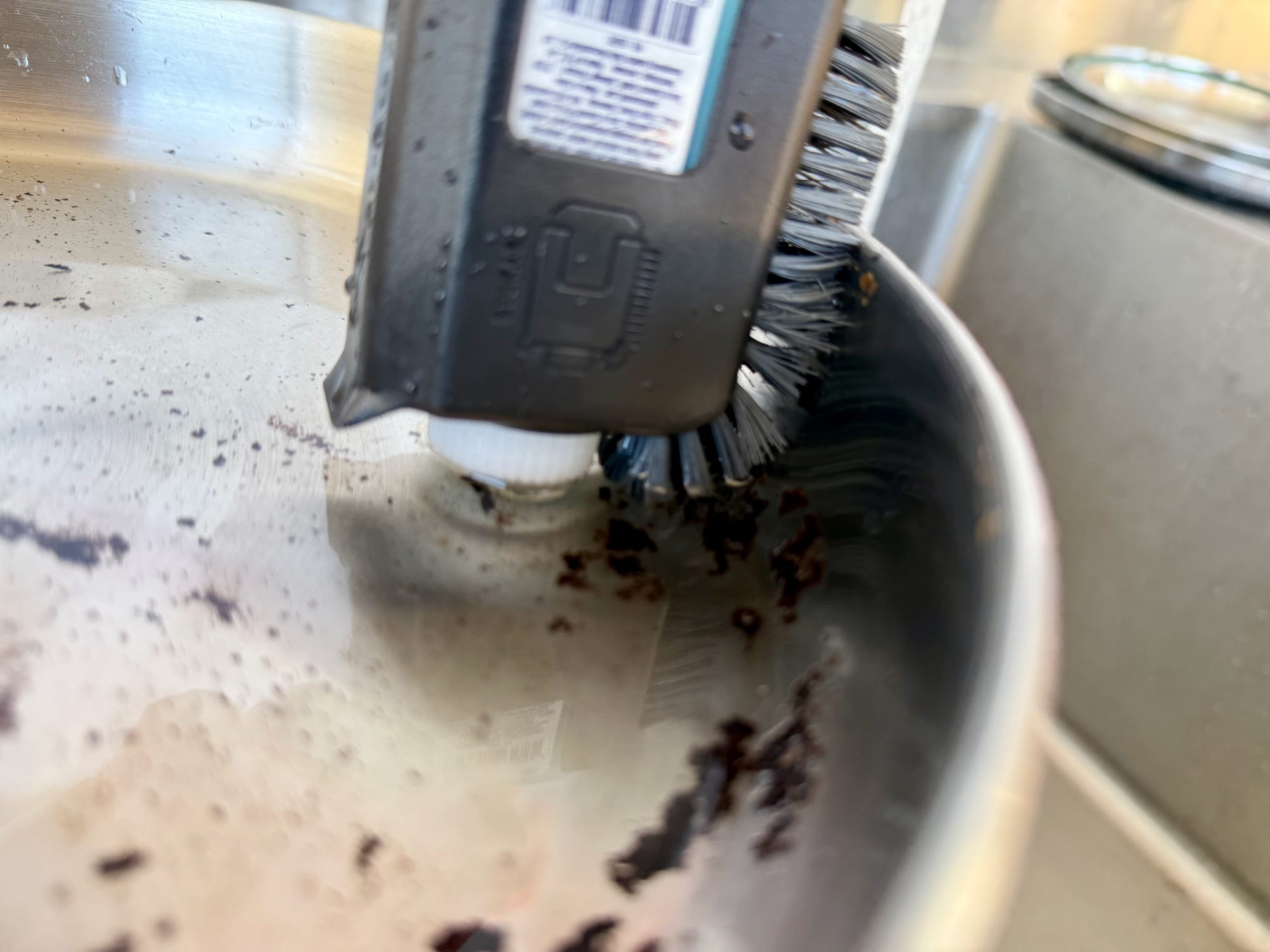 The Sea to Summit Pot Scrubber scrubbing burnt-on egg off the side of the Detour stainless steel pan