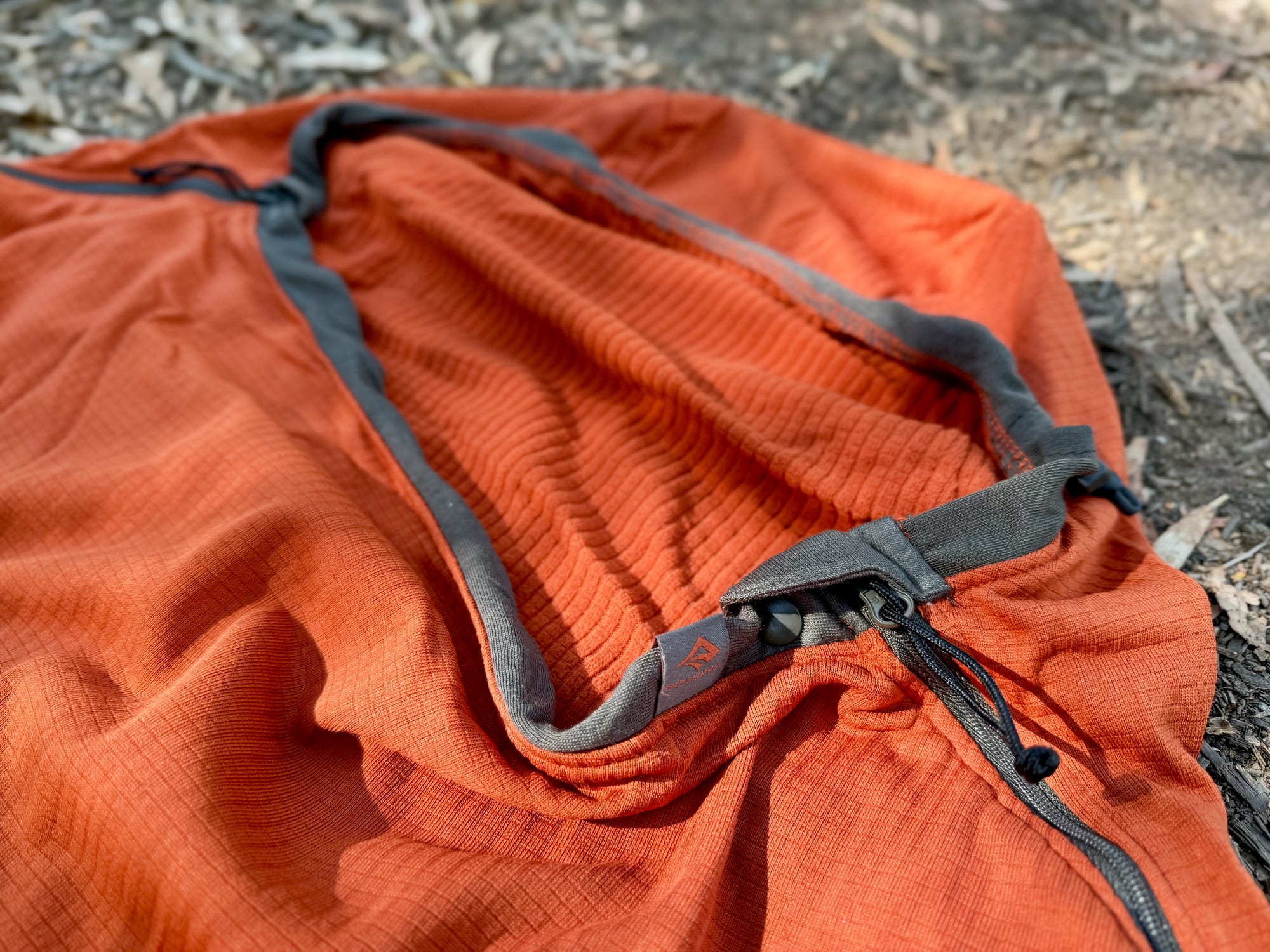 The hood of the Reactor Fleece liner with its grey trim, drawcord and the top of the side zip