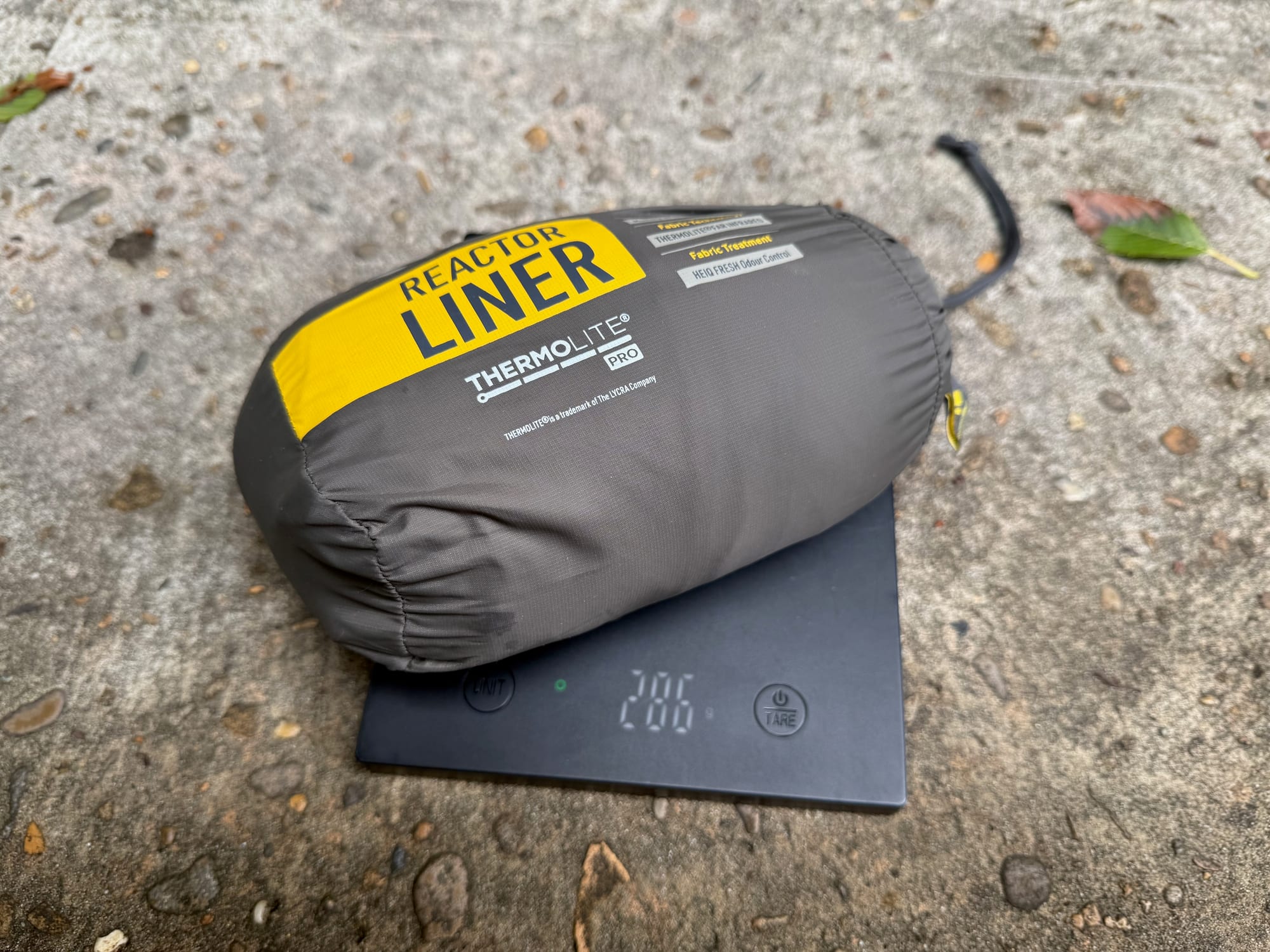 The Sea to Summit Reactor liner in its stuff sack on a scale showing 286 g