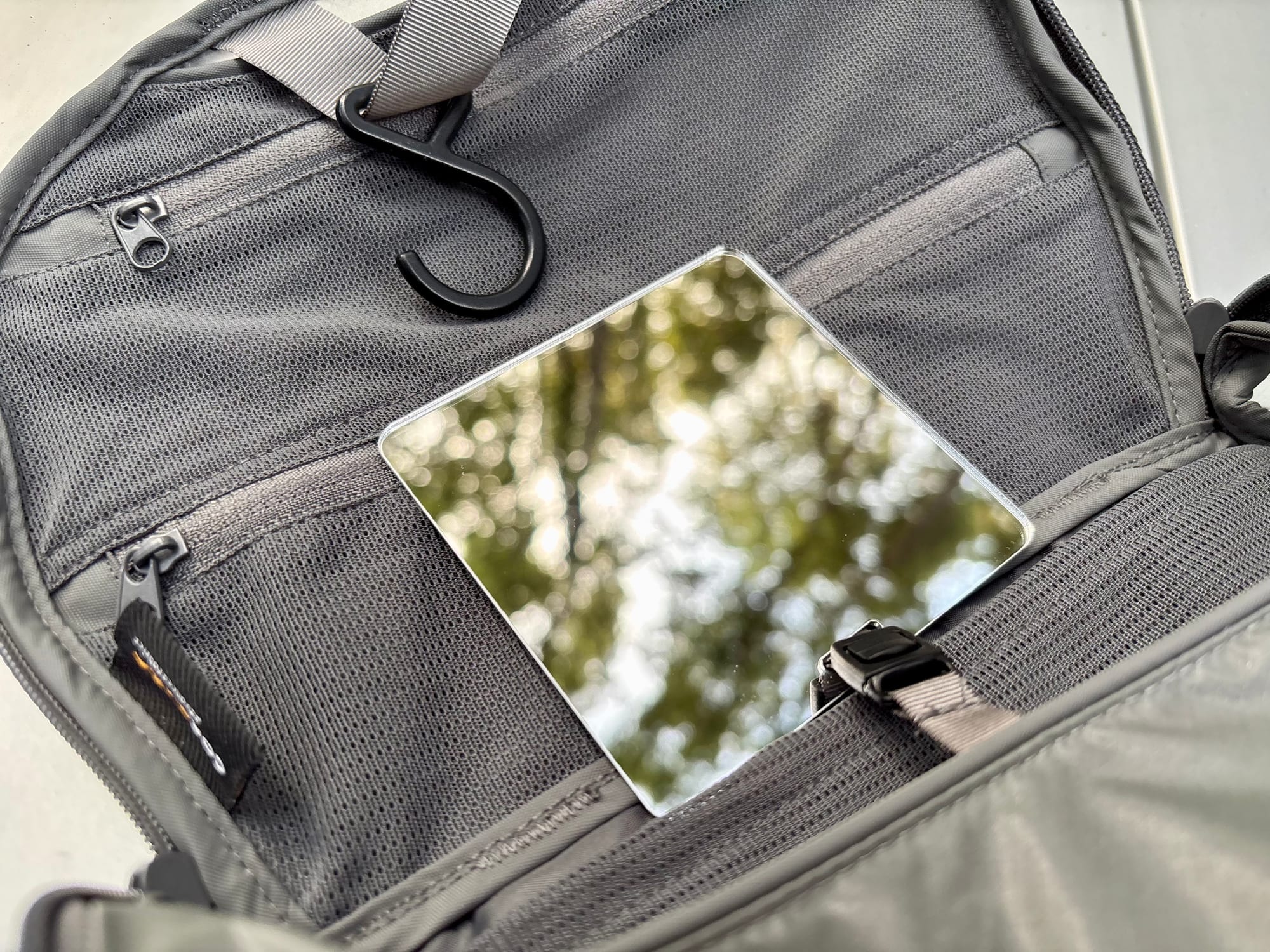 The small mirror clipped inside the Hanging Toiletry Bag