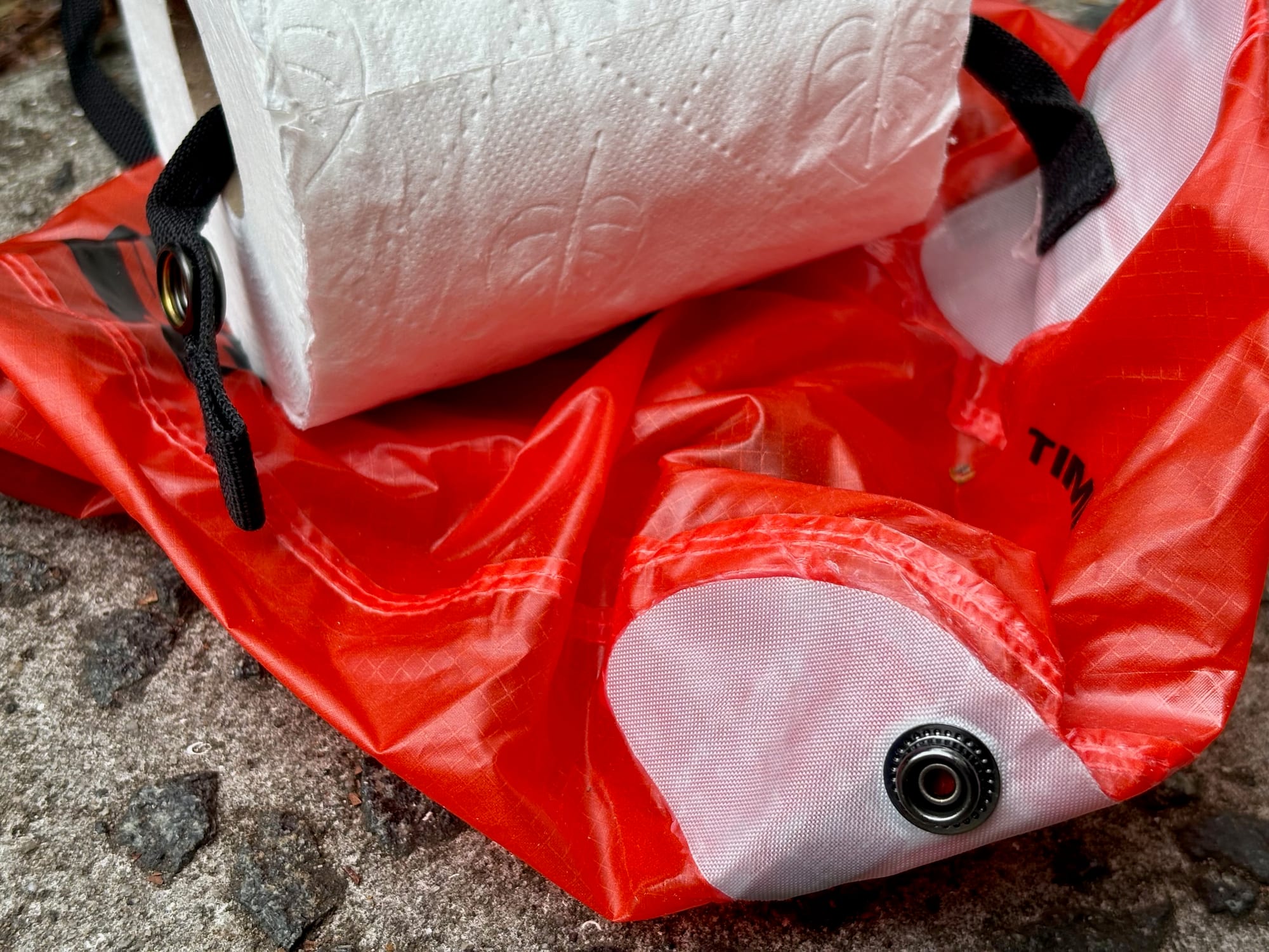 A toilet roll on the dispenser strap inside the Outhouse